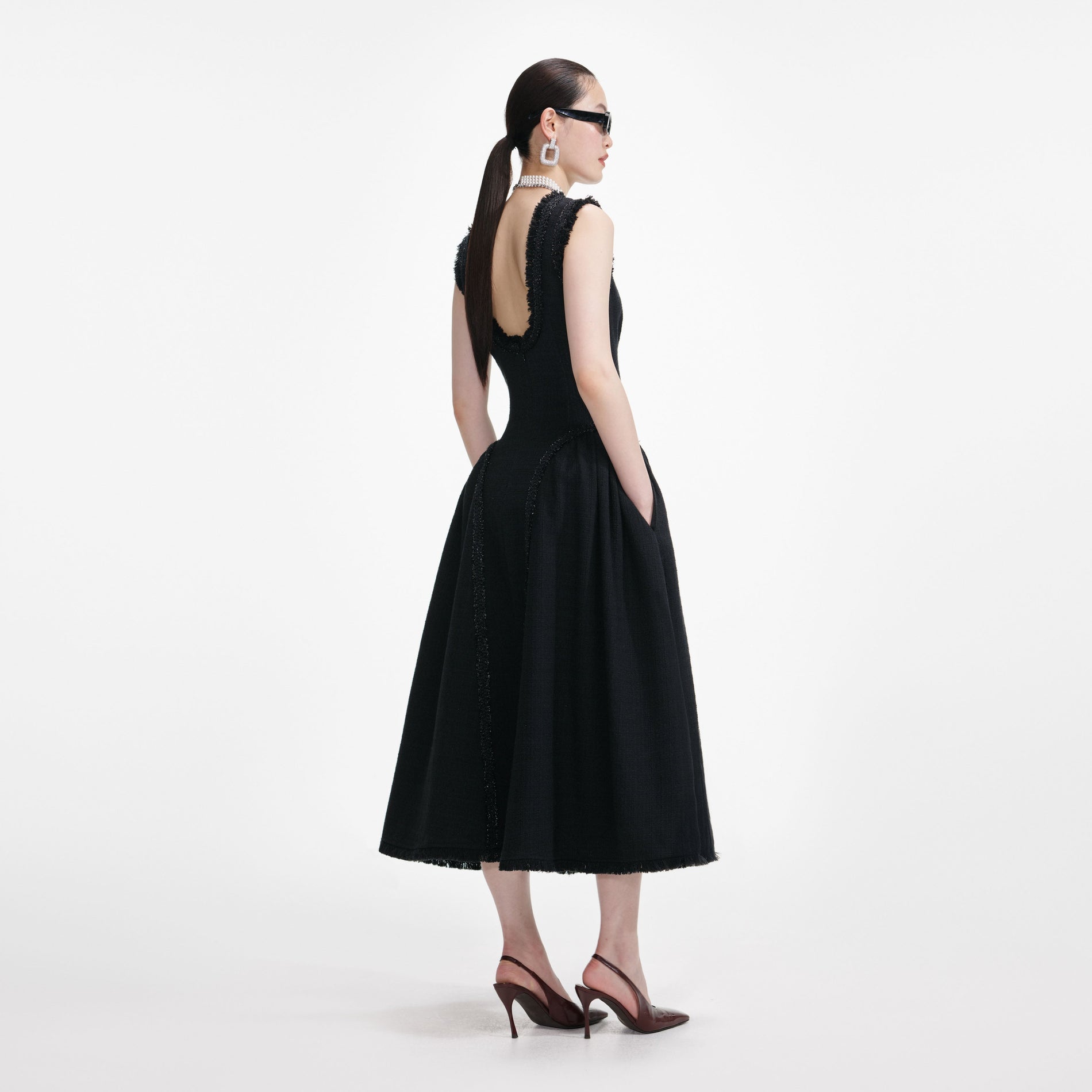 Back view of a woman wearing the Black Boucle Sleeveless Midi Dress