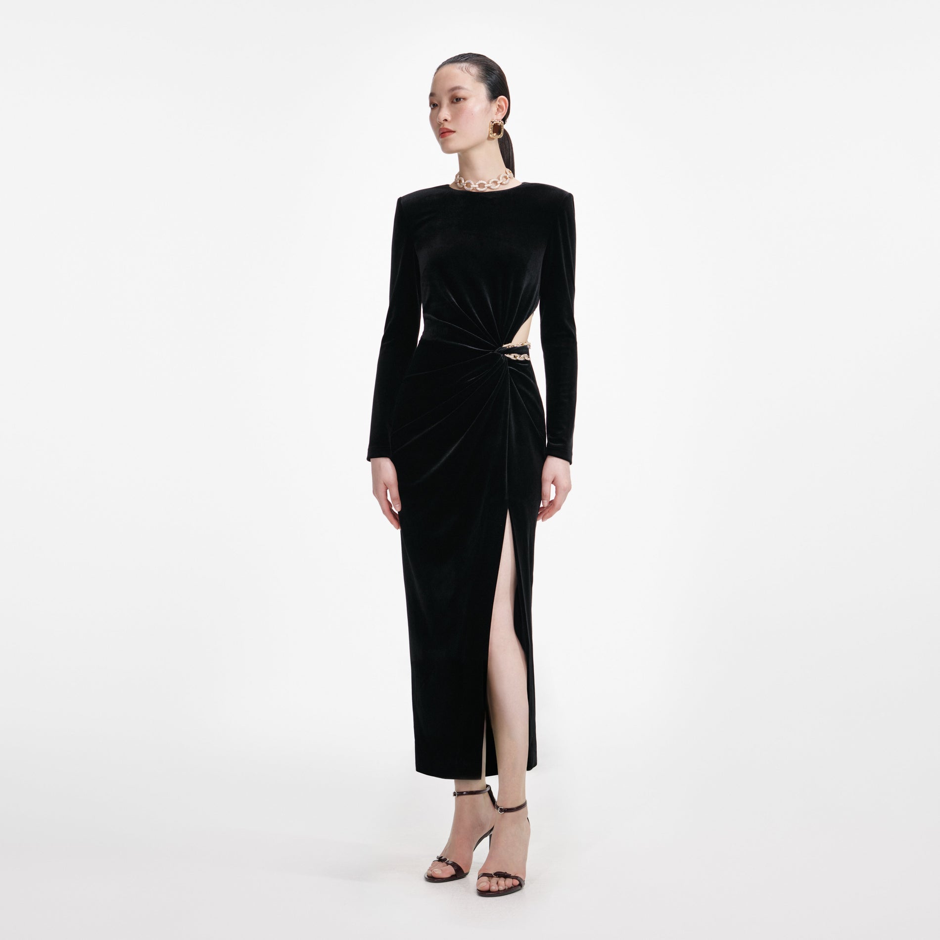Side view of a woman wearing the Black Velvet Embellished Midi Dress