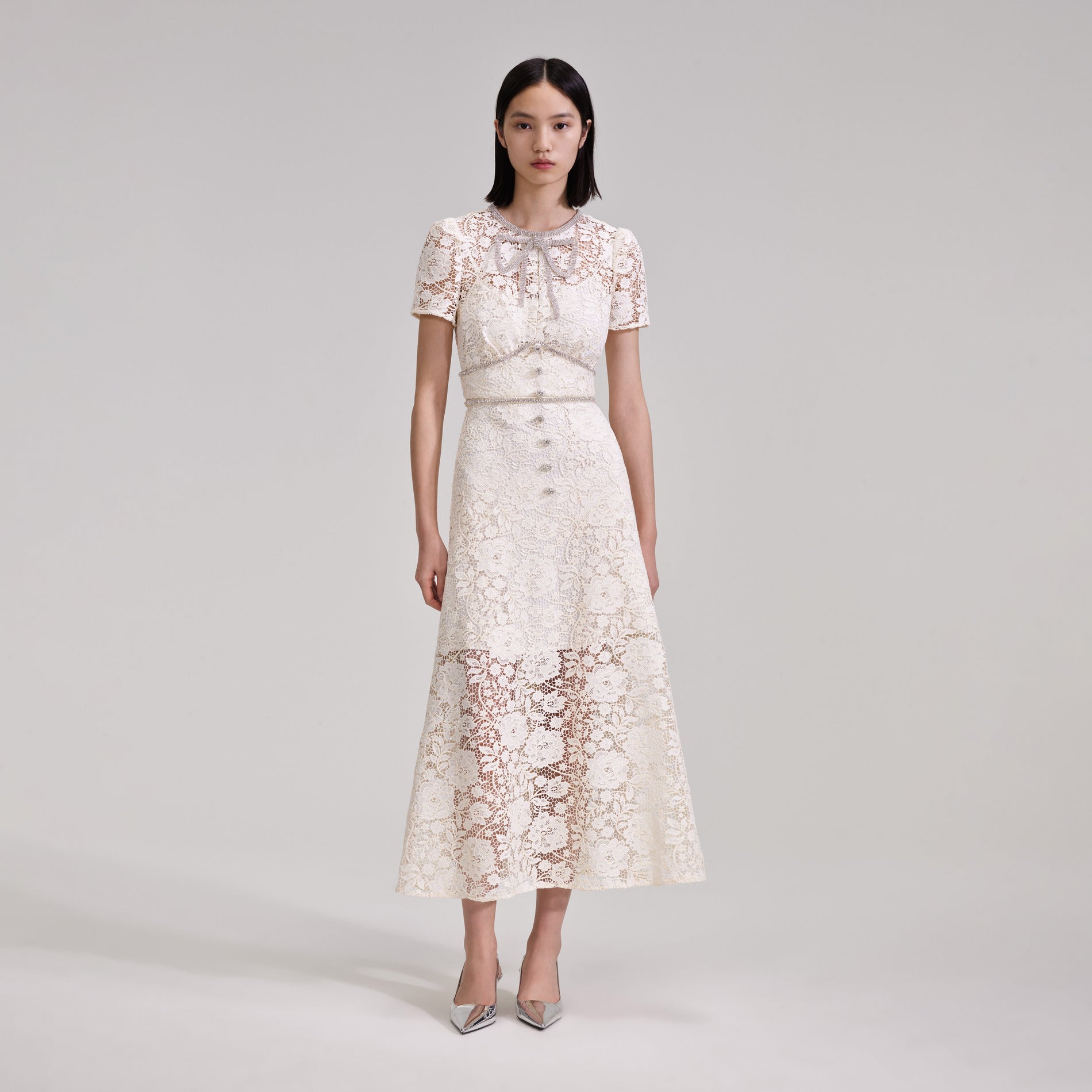 A woman wearing the Cream Cord Lace Bow Midi Dress