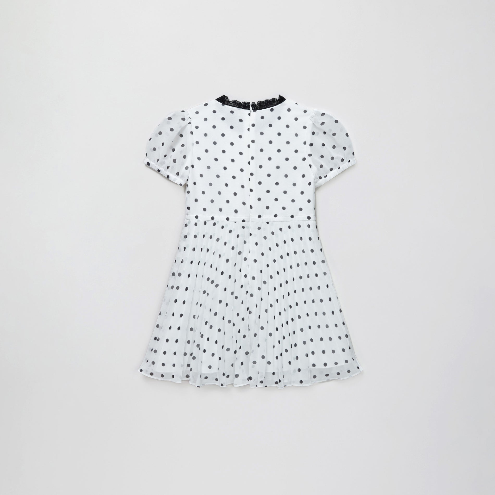 Side view of a woman wearing the Chiffon Polka Dot Dress