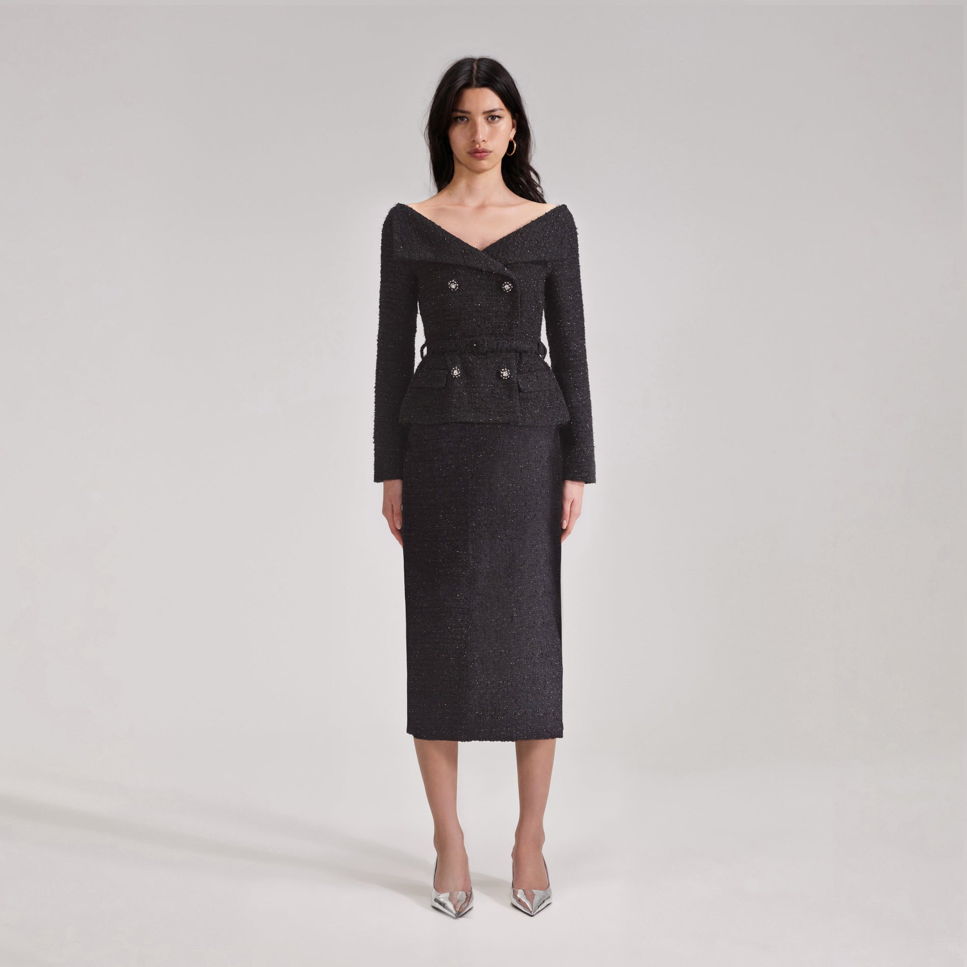 A woman wearing the Black Off Shoulder Boucle Midi Dress