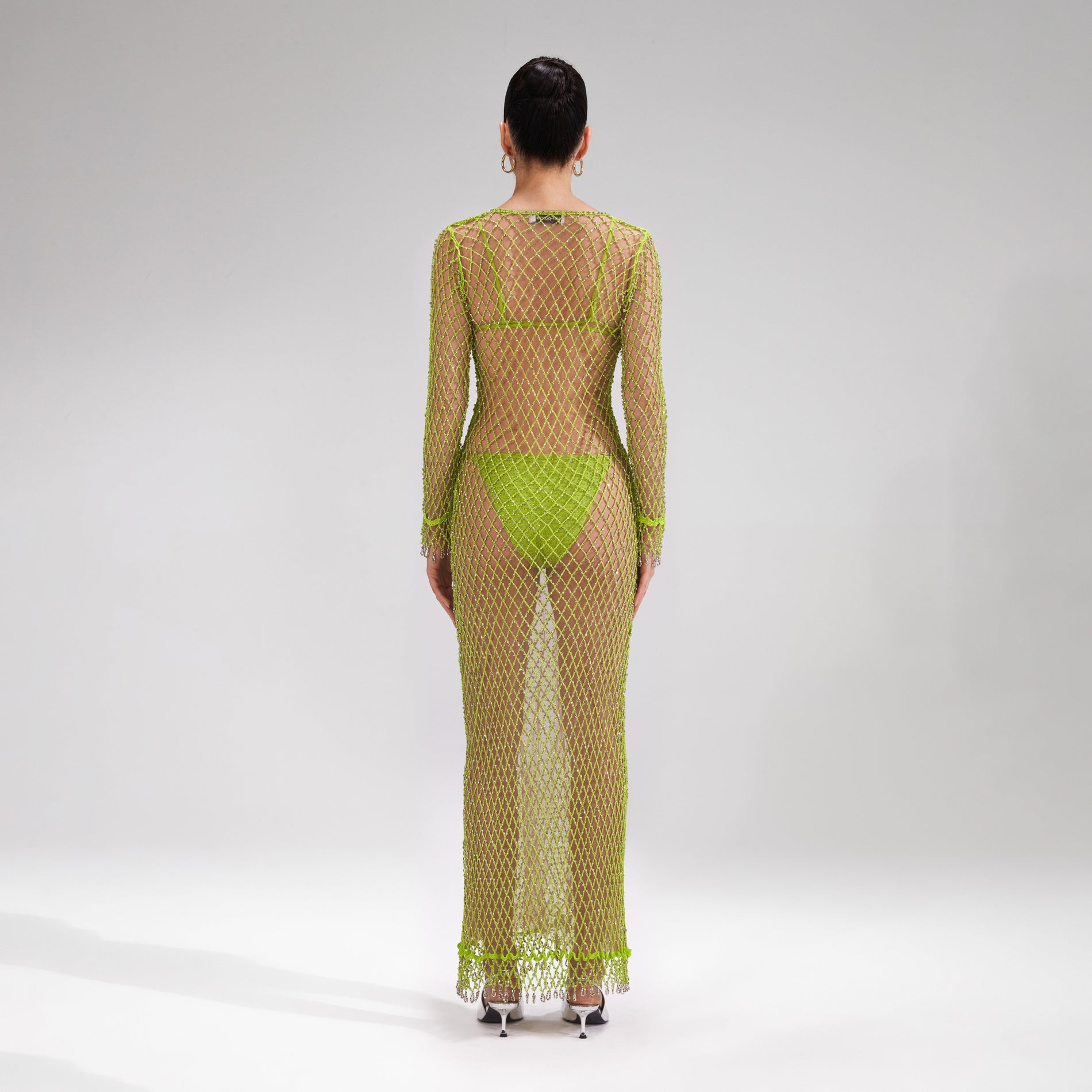 A woman wearing the Green Beaded Fishnet Midi Dress