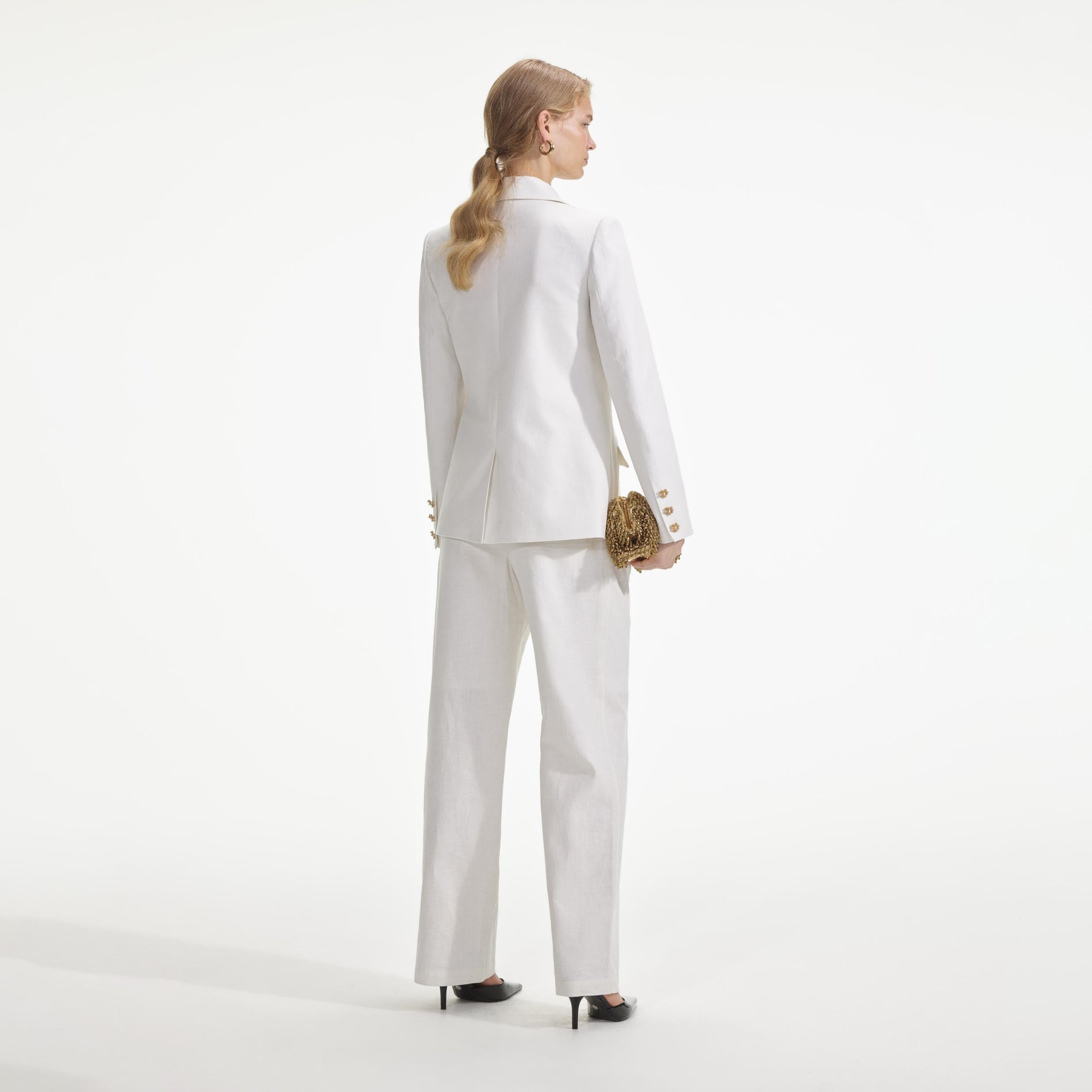 Back view of a woman wearing the White Linen Trousers