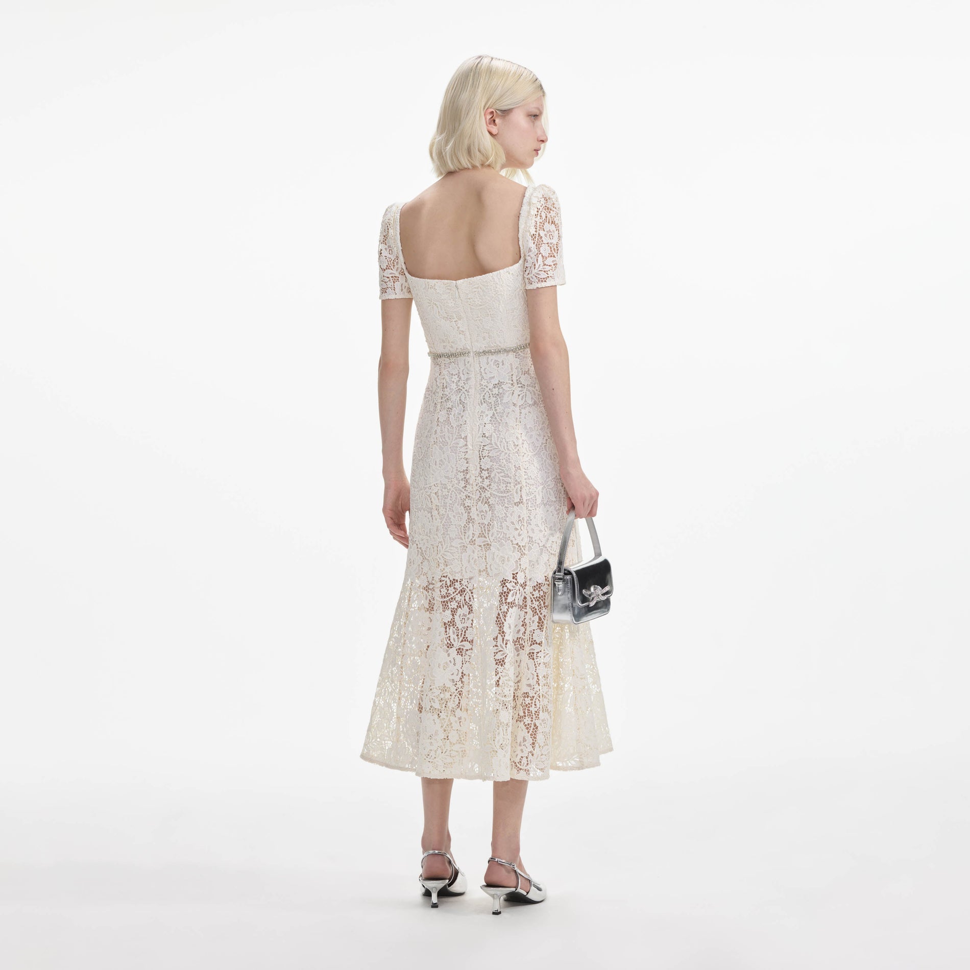 Back view of a woman wearing the Cream Lace Diamante Bow Midi Dress