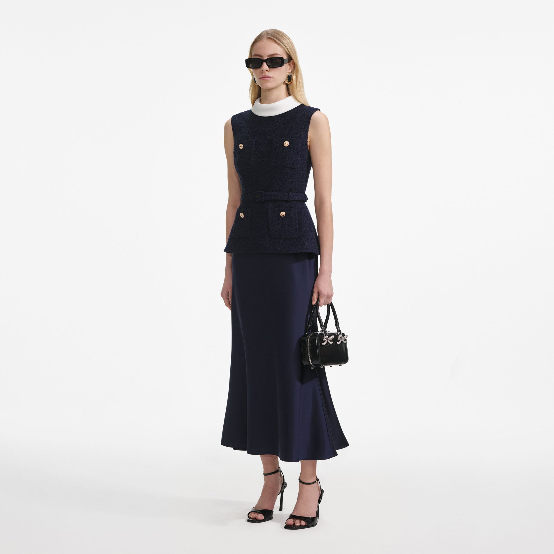 Side view of a woman wearing the Navy Boucle Sleeveless Midi Dress