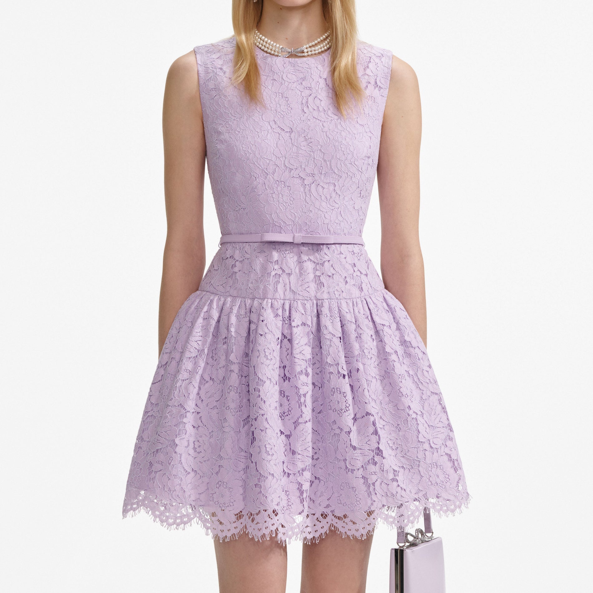 A close up of a woman wearing the Lilac Lace Sleeveless Mini Dress