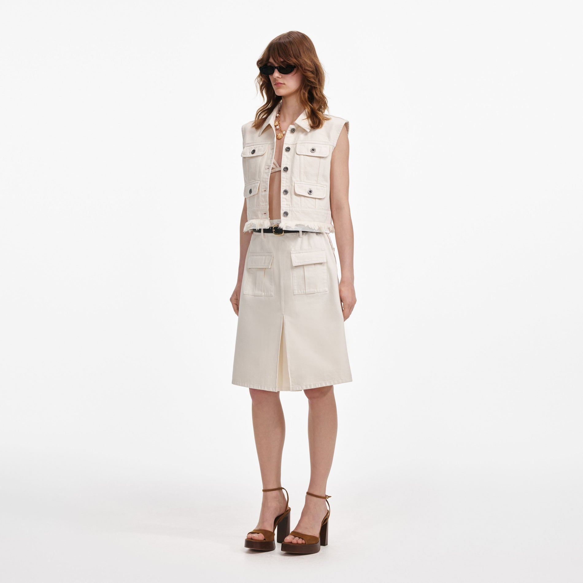 Side view of a woman wearing the Cream Denim Midi Skirt