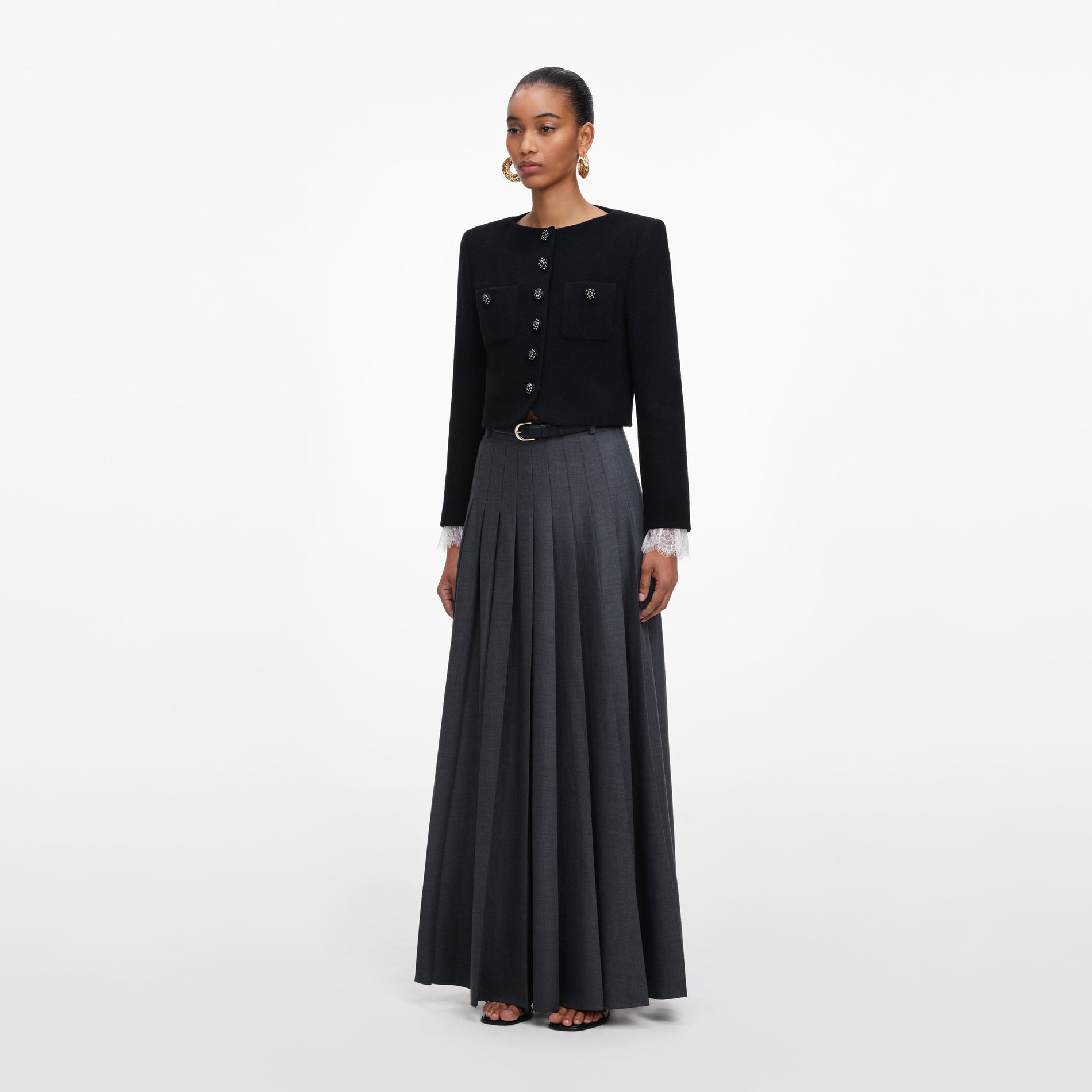 Side view of a woman wearing the Grey Pleated Maxi Skirt