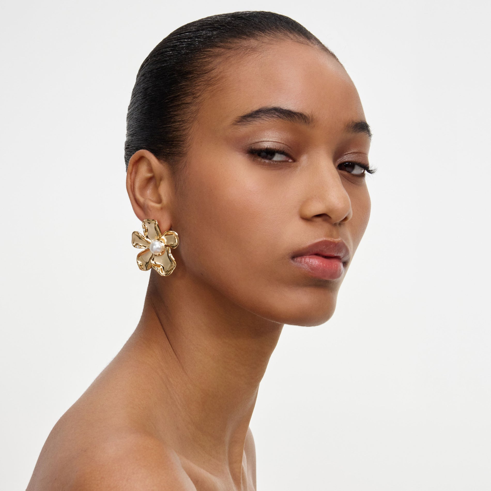 A close up of a woman wearing the Gold Pearl Flower Earrings