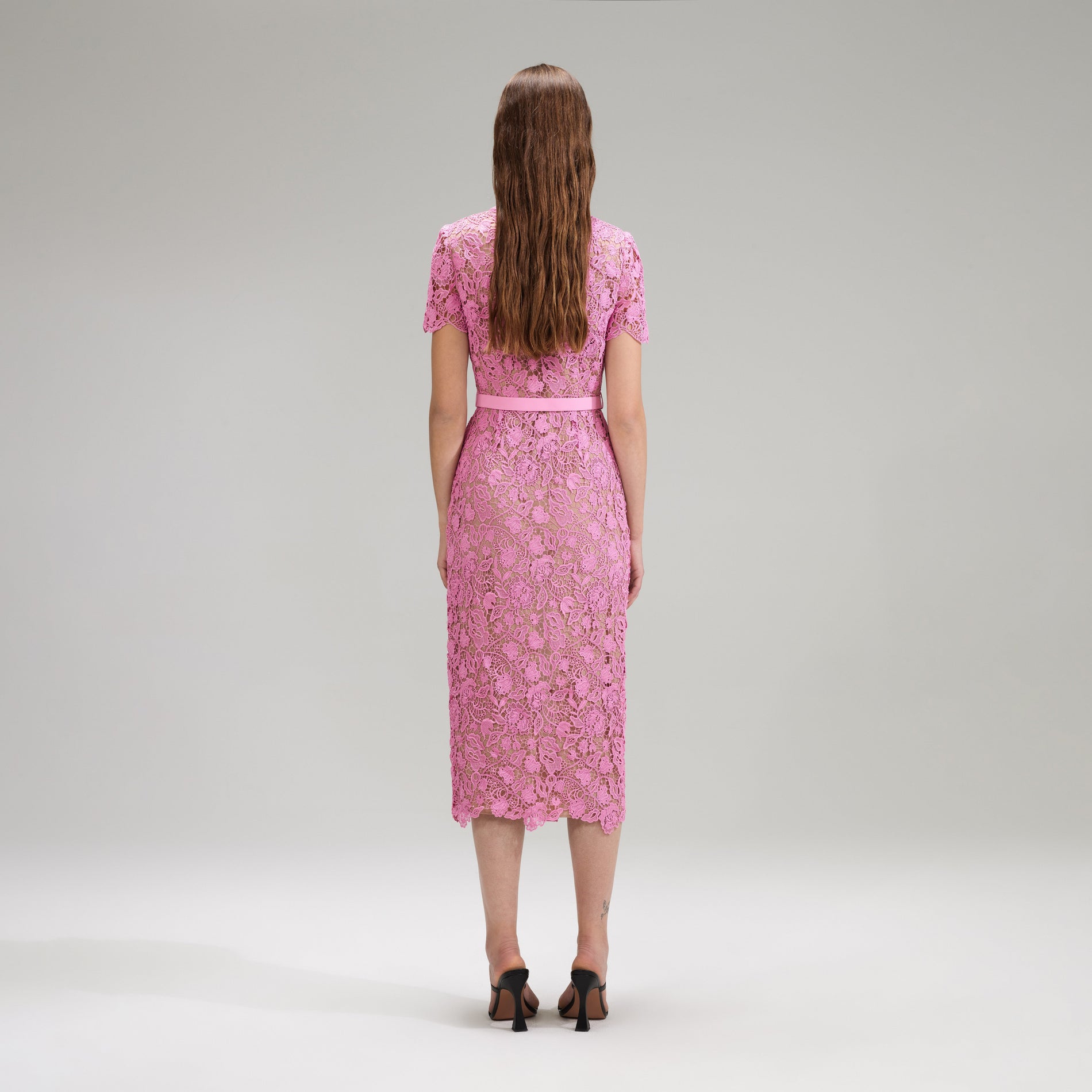 A woman wearing the Pink Guipure Lace Midi Dress