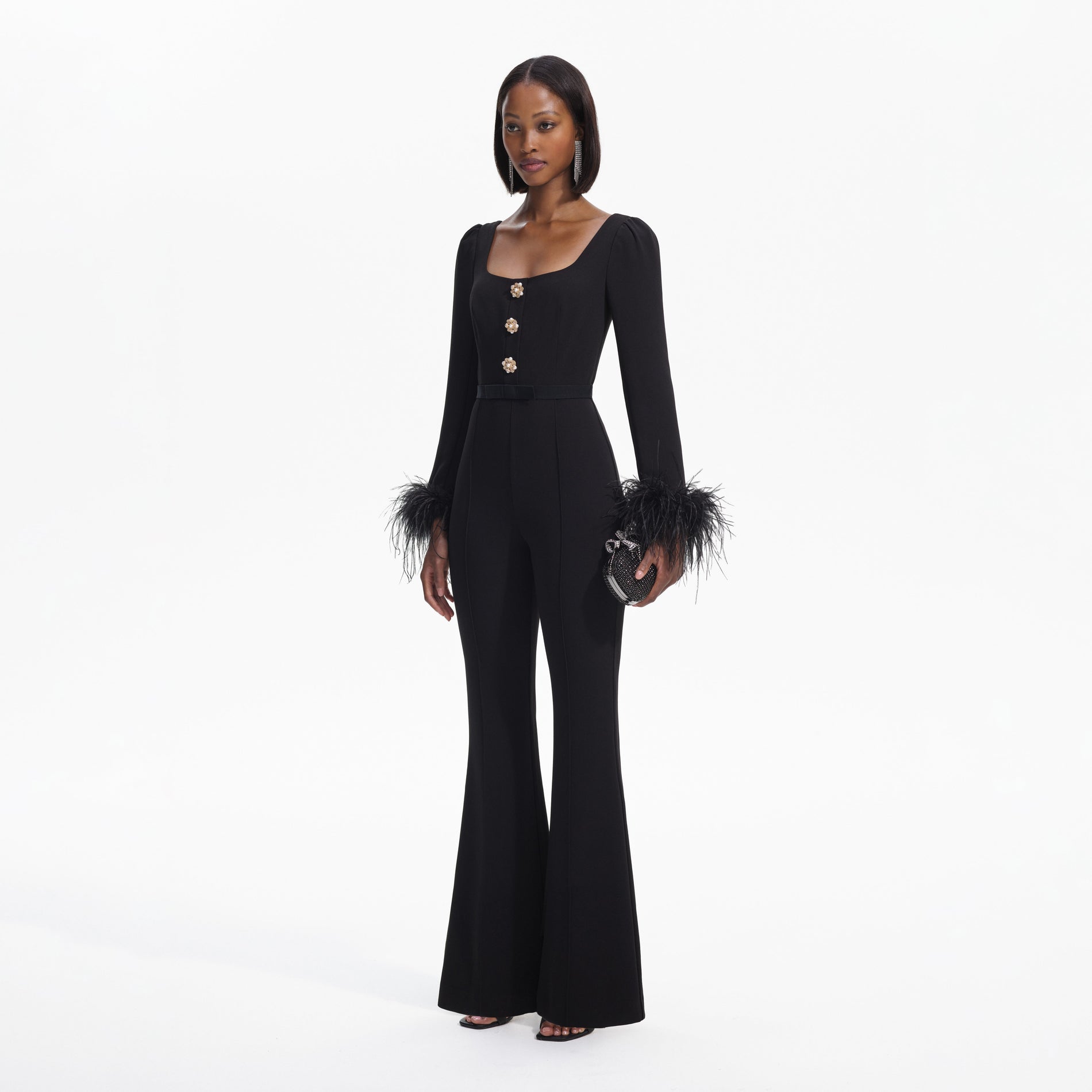 Side view of a woman wearing the Black Crepe Feather Jumpsuit