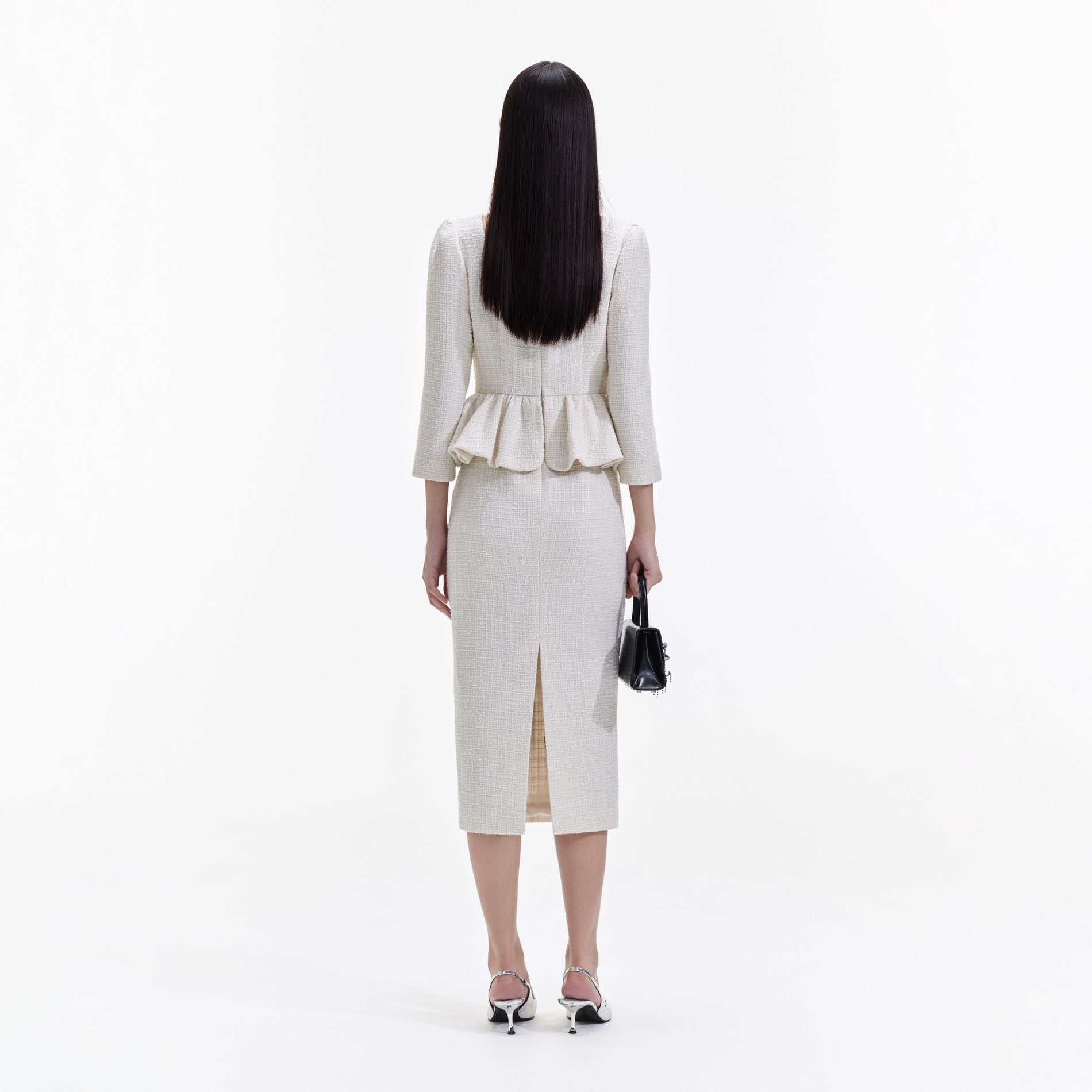 Back view of a woman wearing the Cream Boucle Peplum Midi Dress