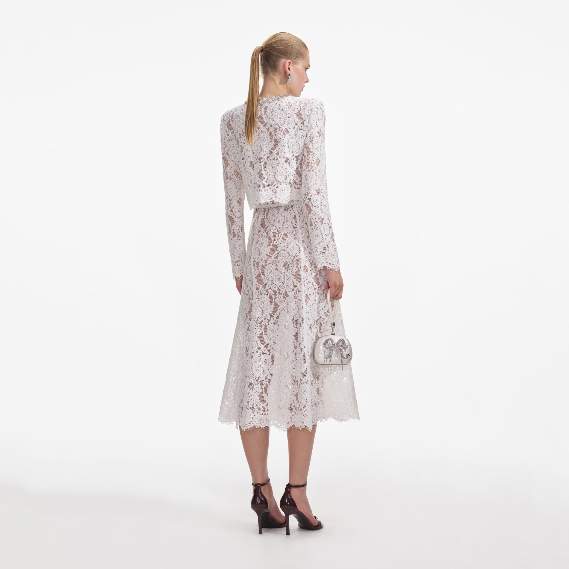 Back view of a woman wearing the White Lace Embellished Midi Dress