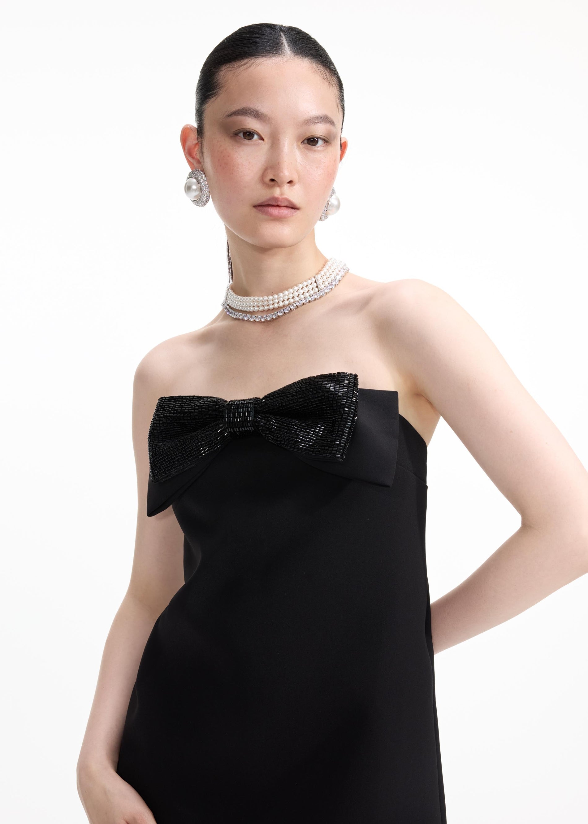 A close up of a woman wearing the Crystal Pearl Earrings