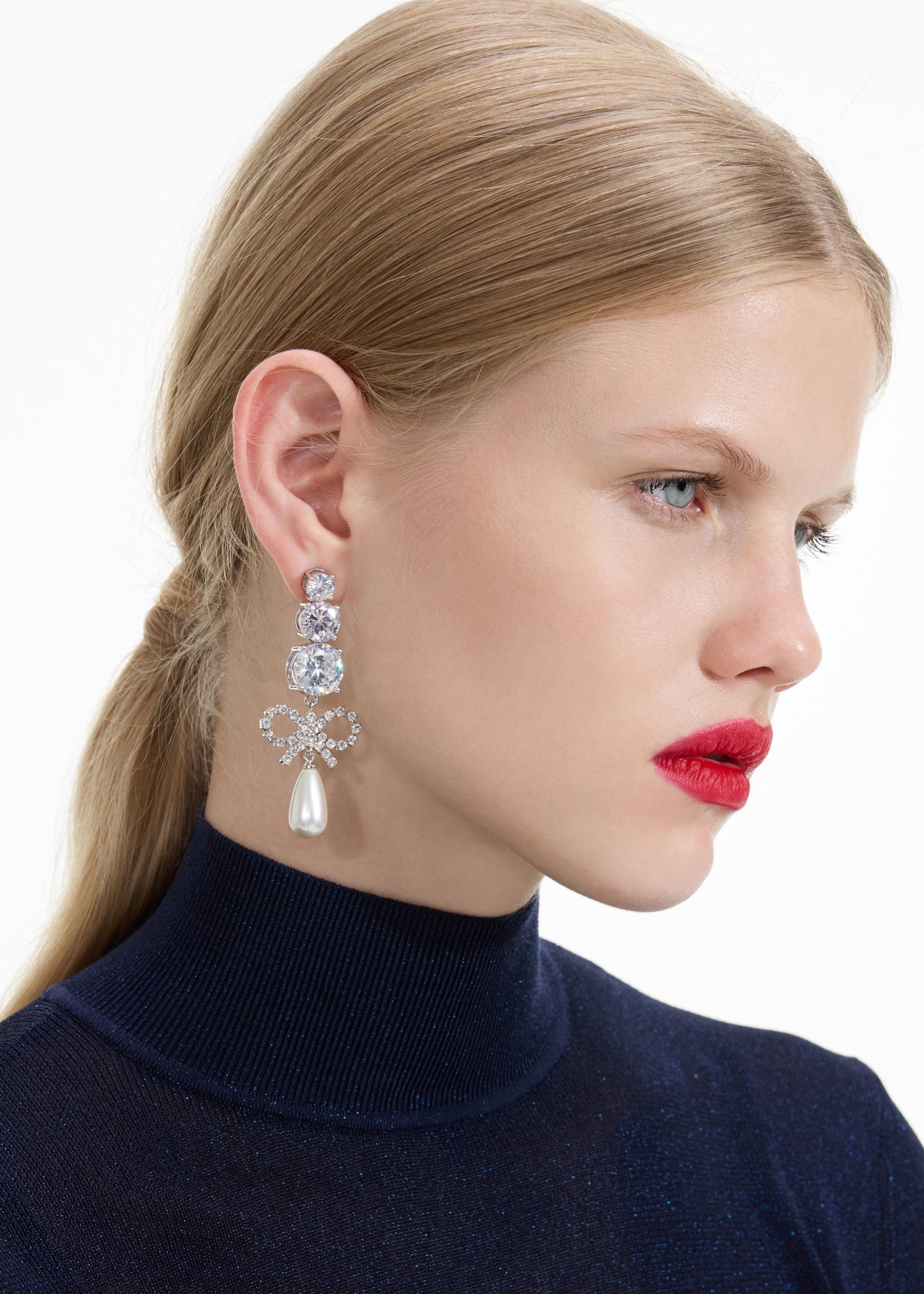 Back view of a woman wearing the Crystal Bow Pearl Earrings