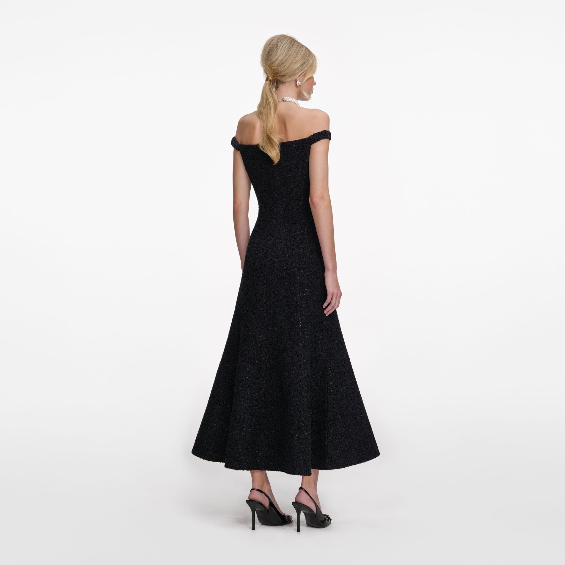 Back view of a woman wearing the Black Boucle Midi Dress