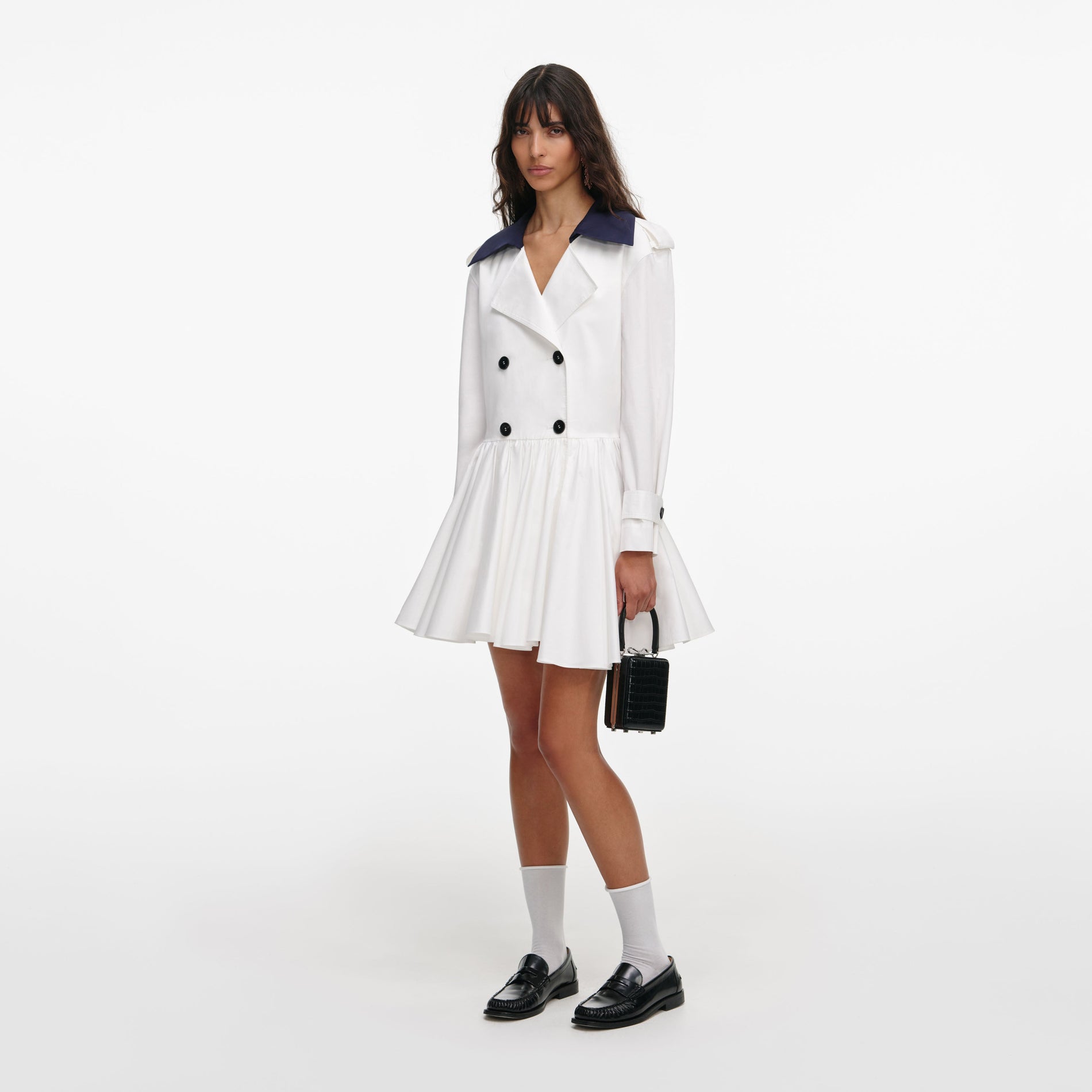 Side view of a woman wearing the White Cotton Double Breasted Mini Dress