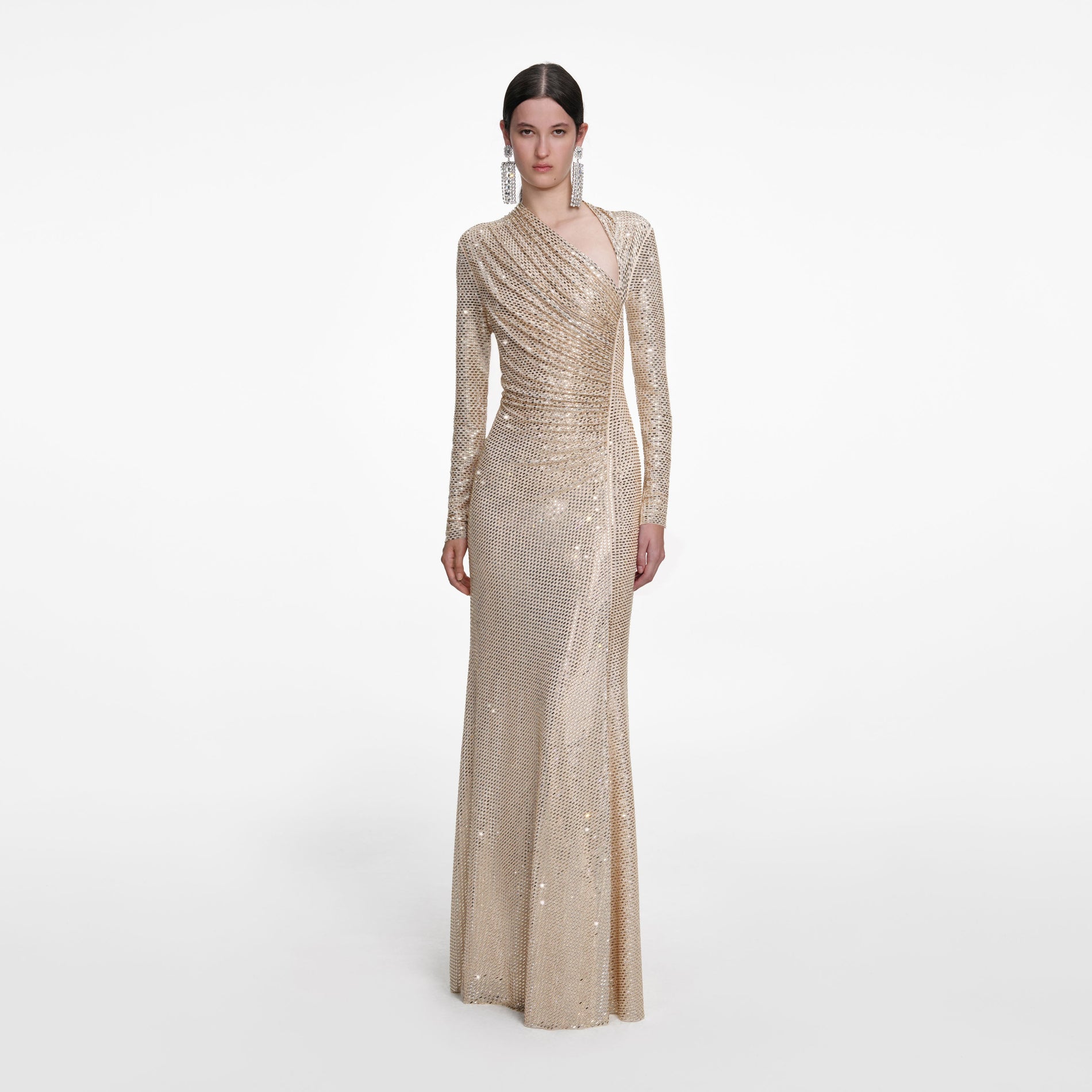 A close up of a woman wearing the Champagne Rhinestone Drape Maxi Dress