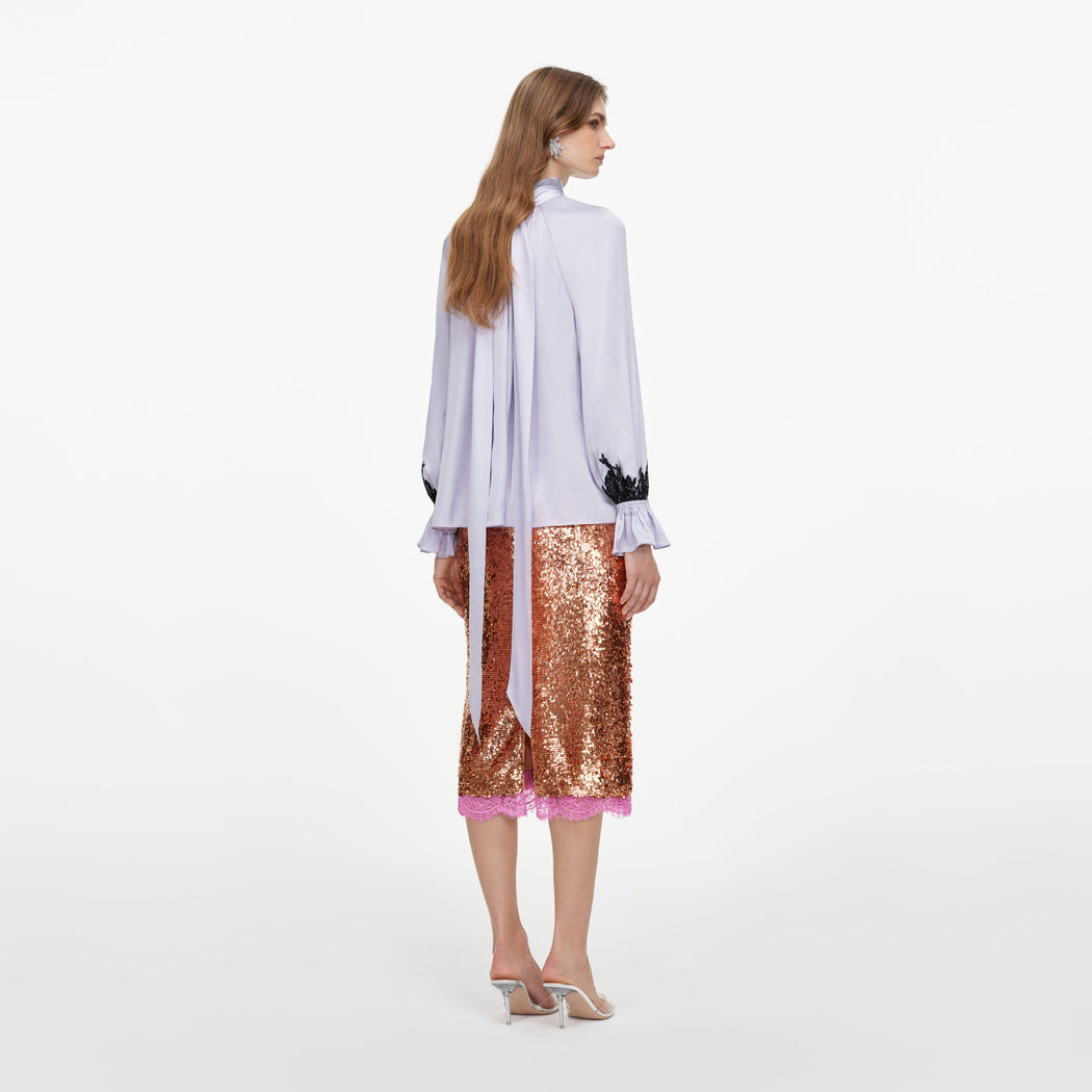 Back view of a woman wearing the Lilac Viscose Contrast Lace Blouse