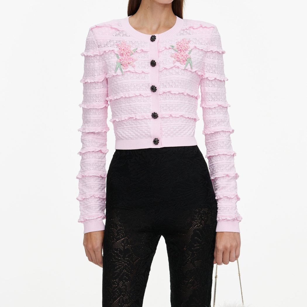 A close up of a woman wearing the Pink Flower Pointelle Knit Cardigan