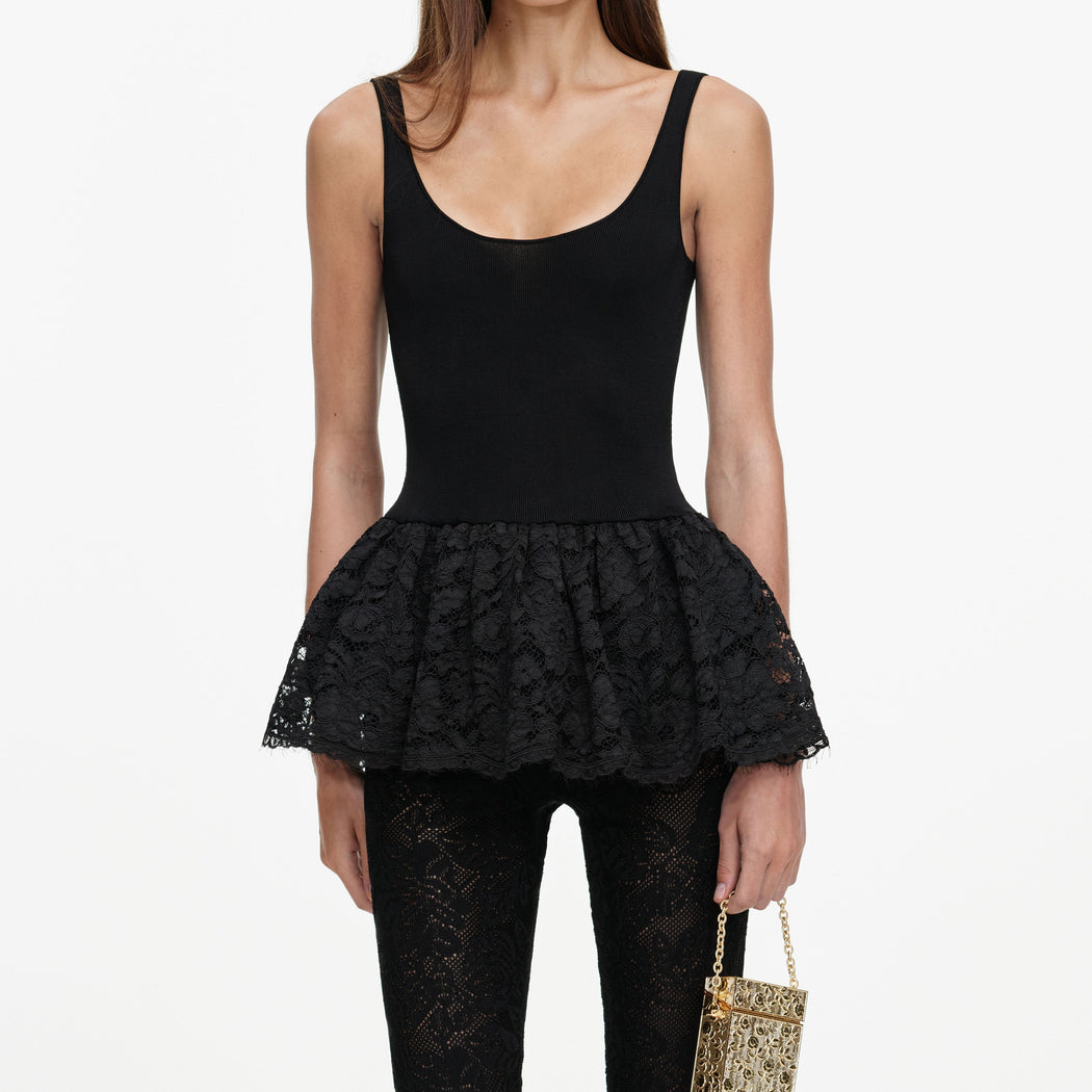 A close up of a woman wearing the Black Peplum Viscose Knit Top