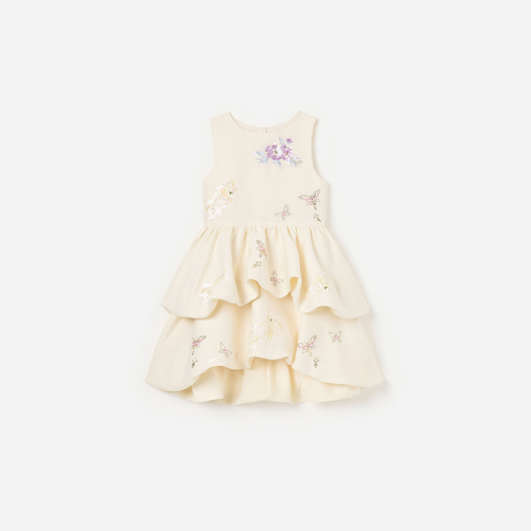 Front view of a girl wearing the Cream Floral Jacquard Dress
