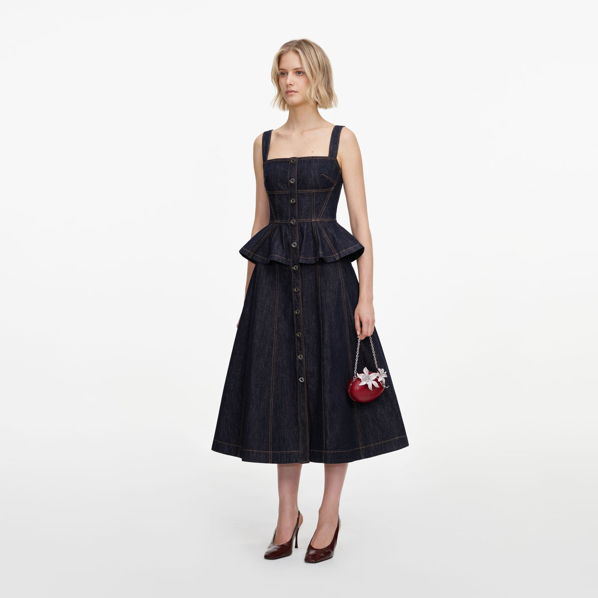 Side view of a woman wearing the Indigo Peplum Denim Midi Dress