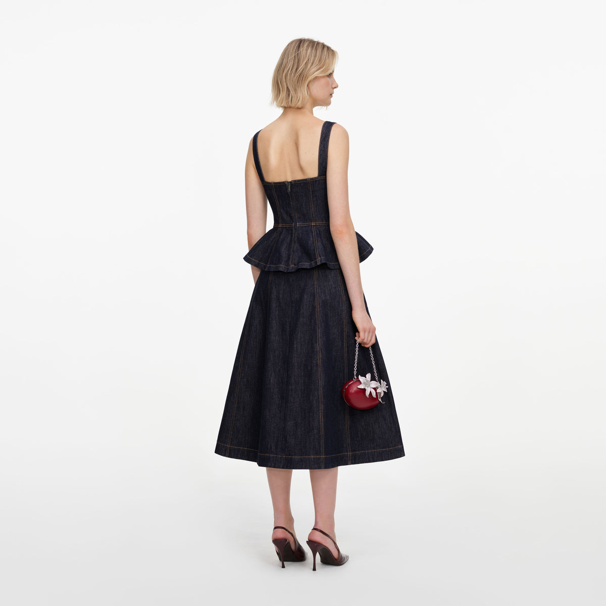 Back view of a woman wearing the Indigo Peplum Denim Midi Dress