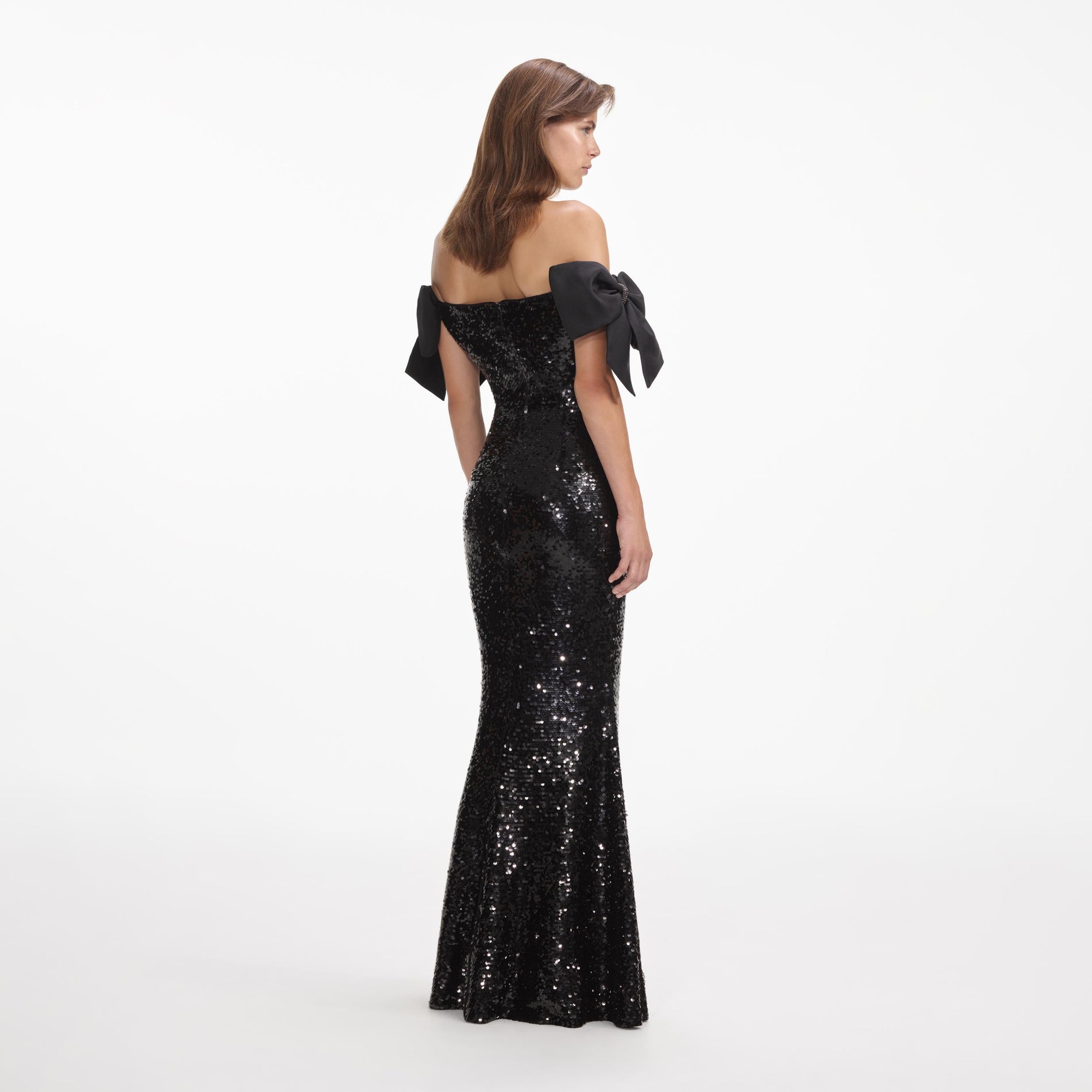 Back view of a woman wearing the Black Sequin Bow Maxi Dress