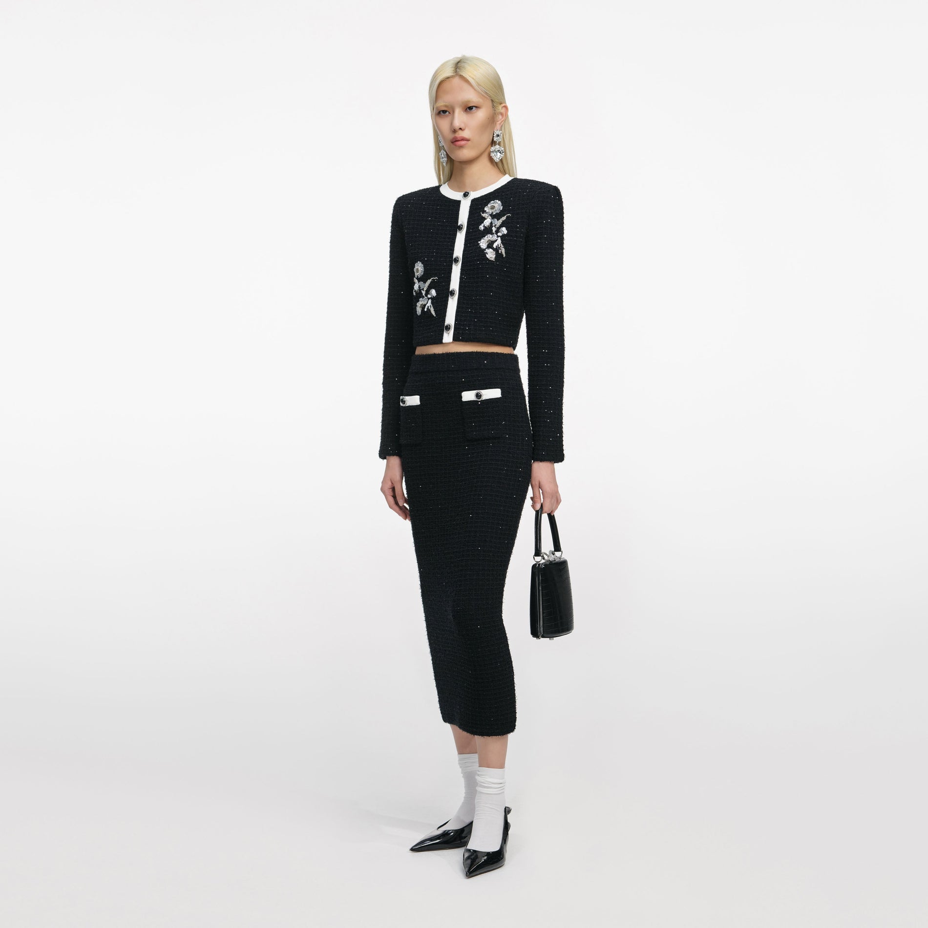 Side view of a woman wearing the Black Floral Textured Knit Jacket