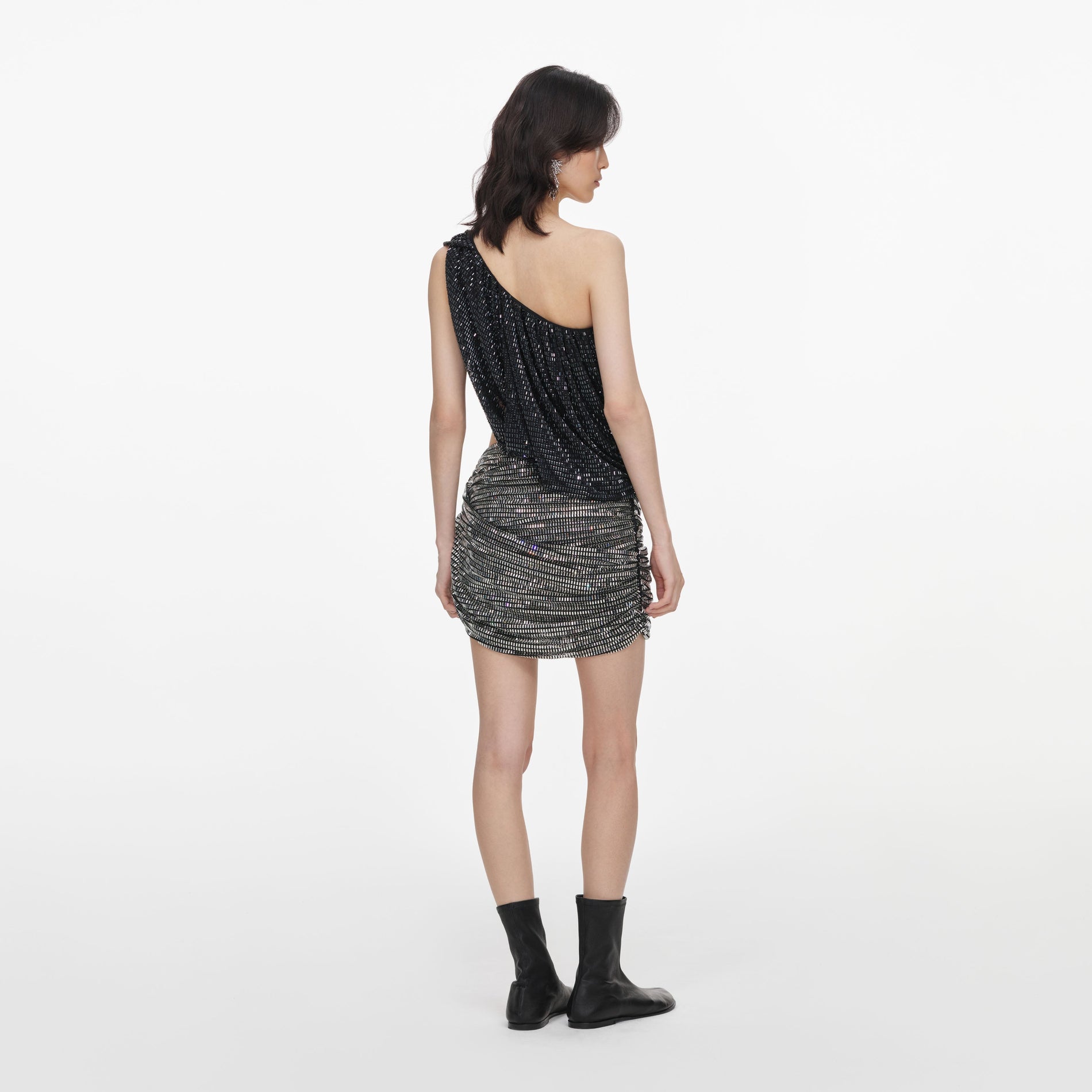 Back view of a woman wearing the Black Rhinestone One Shoulder Drape Top