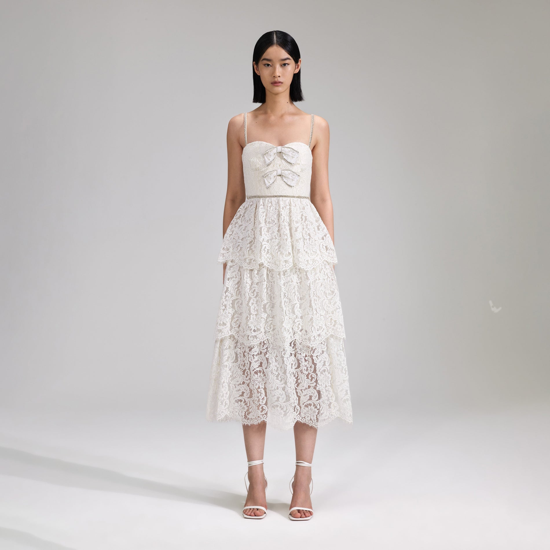 A woman wearing the Cream Cord Lace Tiered Midi Dress