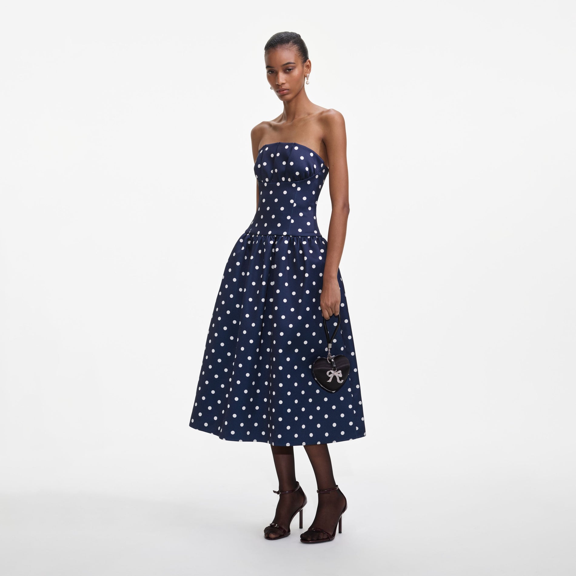 Side view of a woman wearing the Navy Polka Dot Satin Midi Dress
