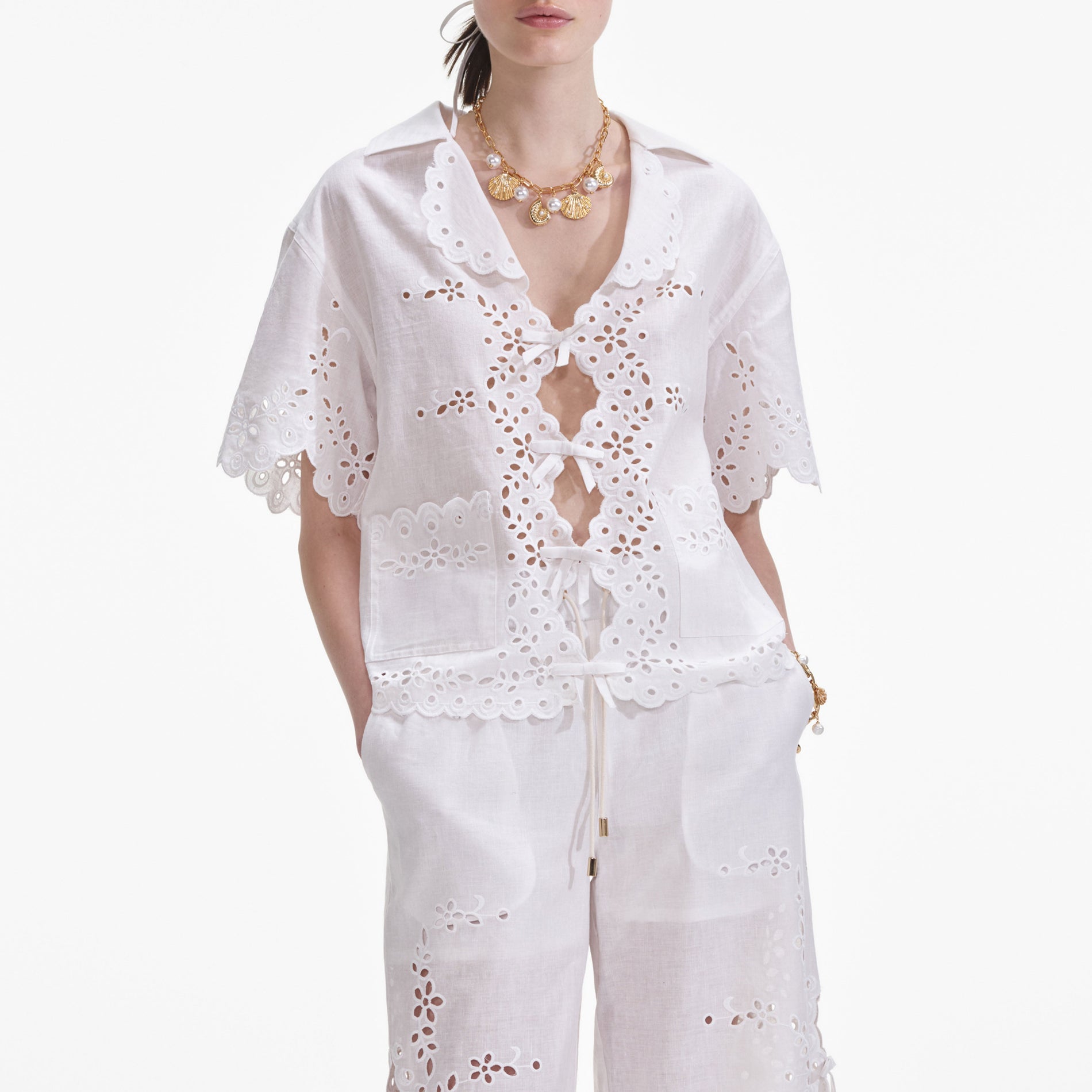A close up of a woman wearing the Cream Linen Embroidered Shirt