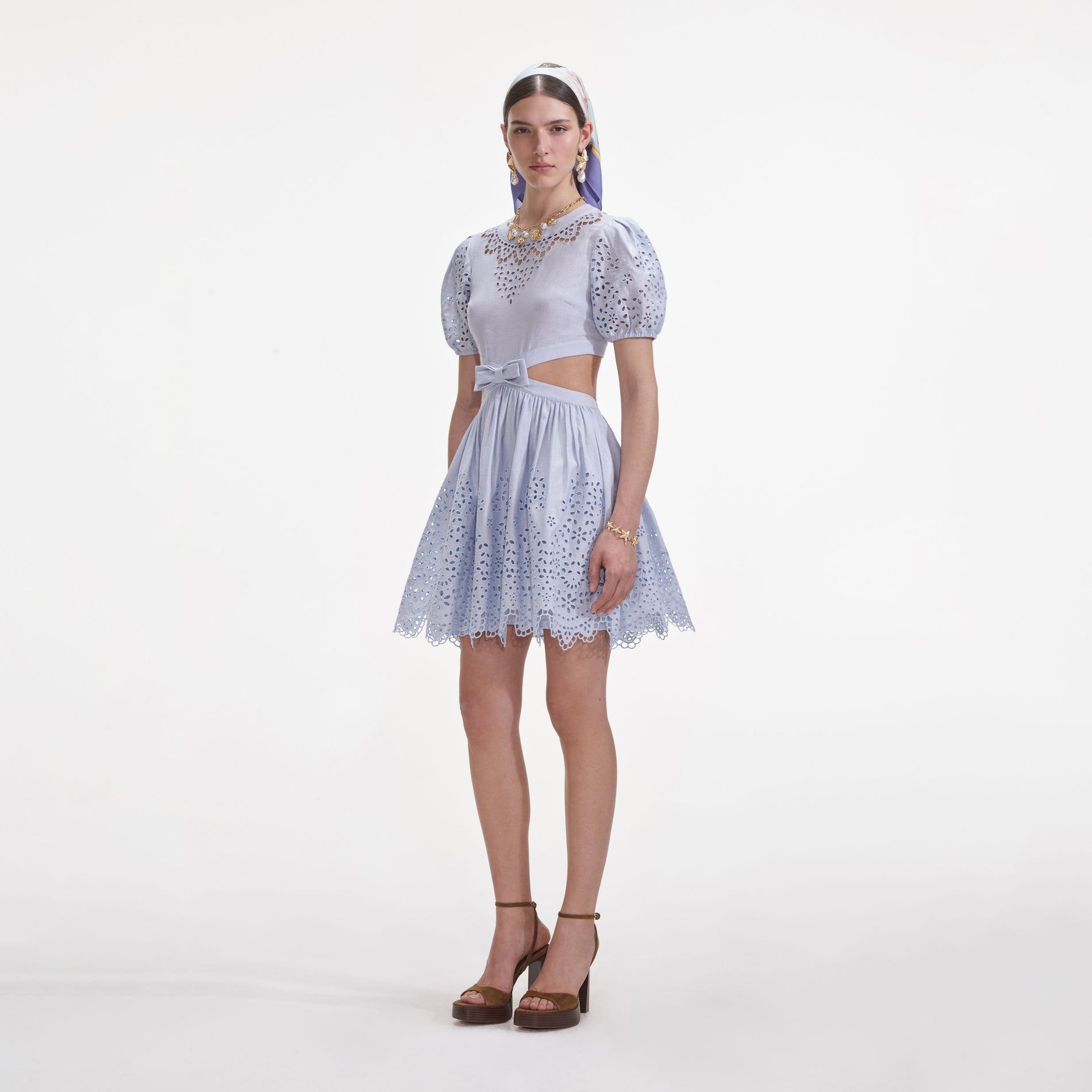 Side view of a woman wearing the Blue Embroidered Linen Mini Dress