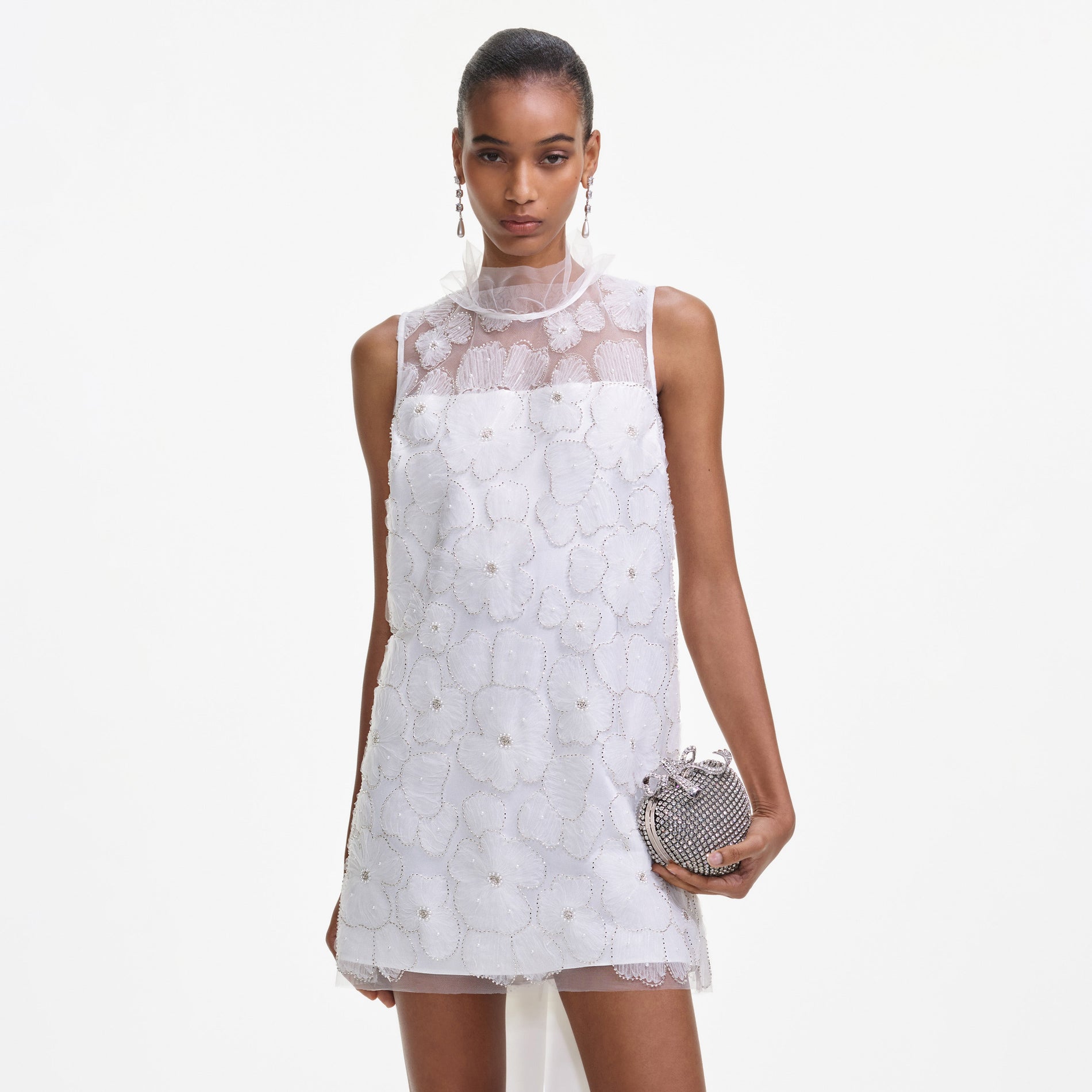 A close up of a woman wearing the White Tulle Satin Bow Mini Dress