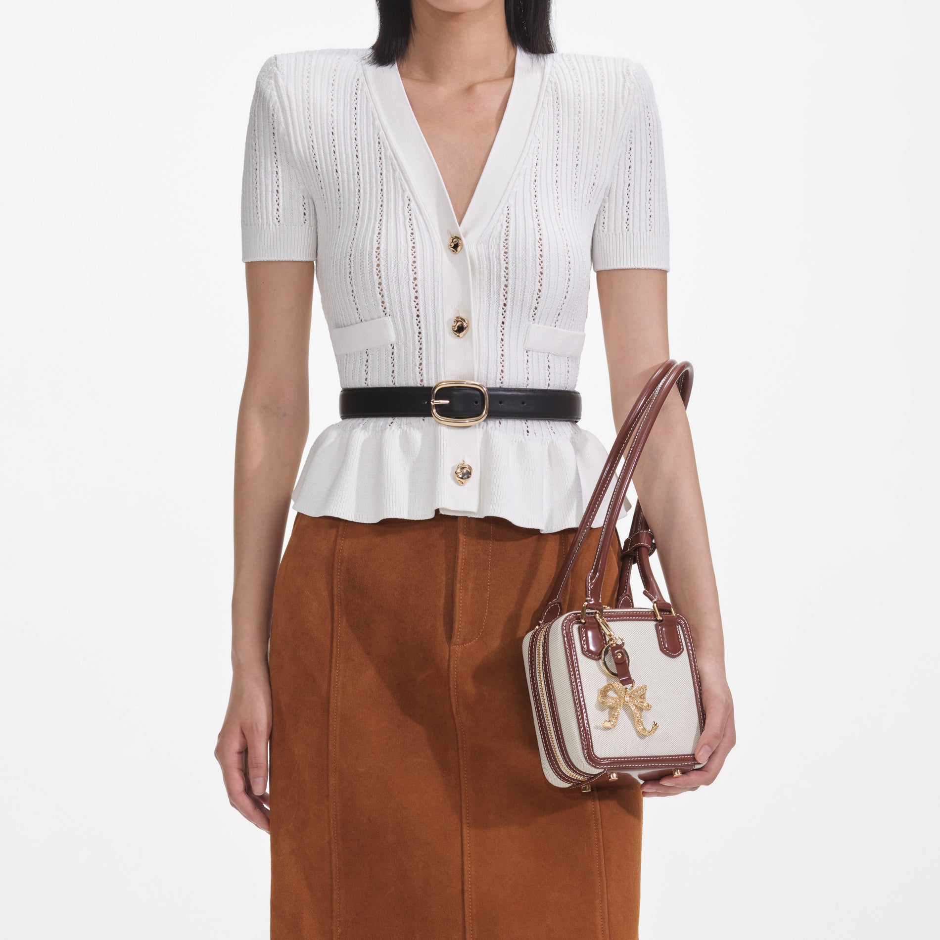 A close up of a woman wearing the White Peplum Knit Top