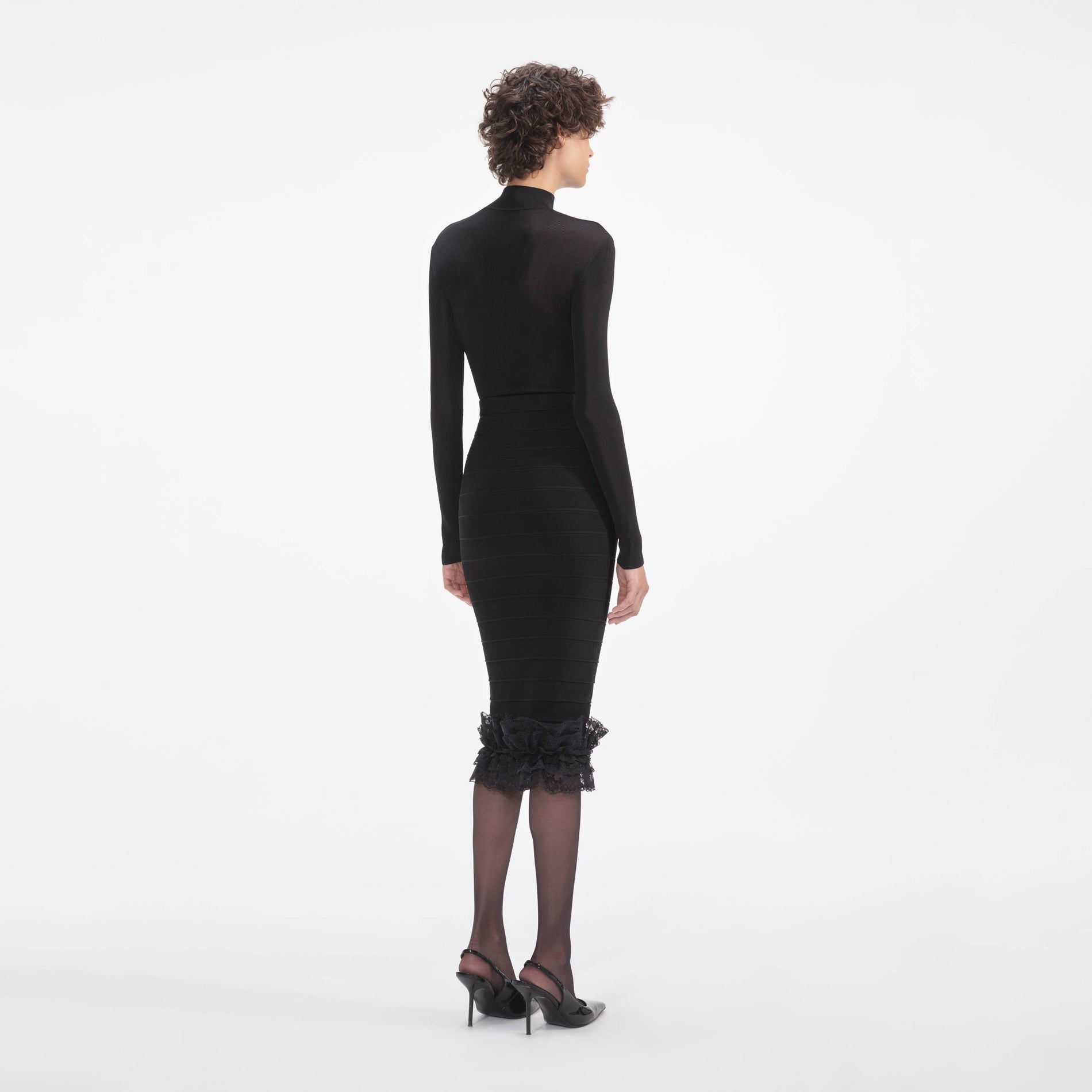 Back view of a woman wearing the Black Ruffle Knit Midi Skirt