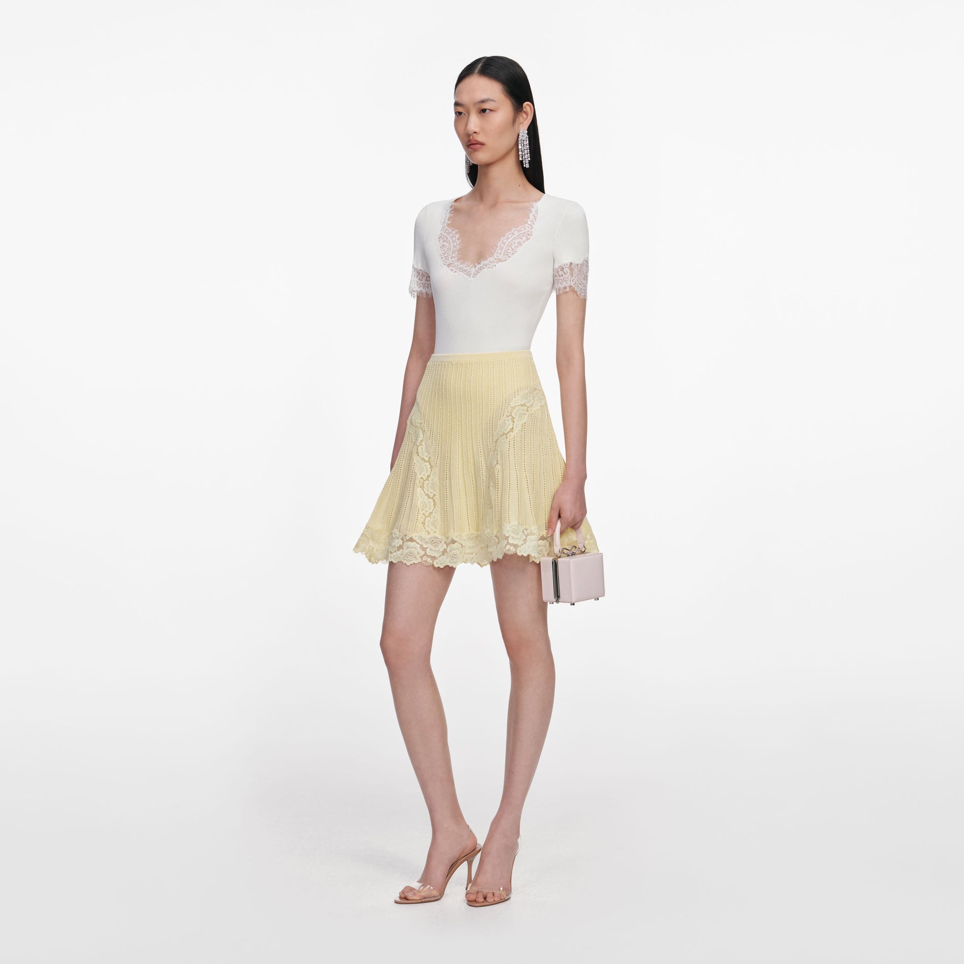 Side view of a woman wearing the Yellow Pointelle Knit Mini Skirt