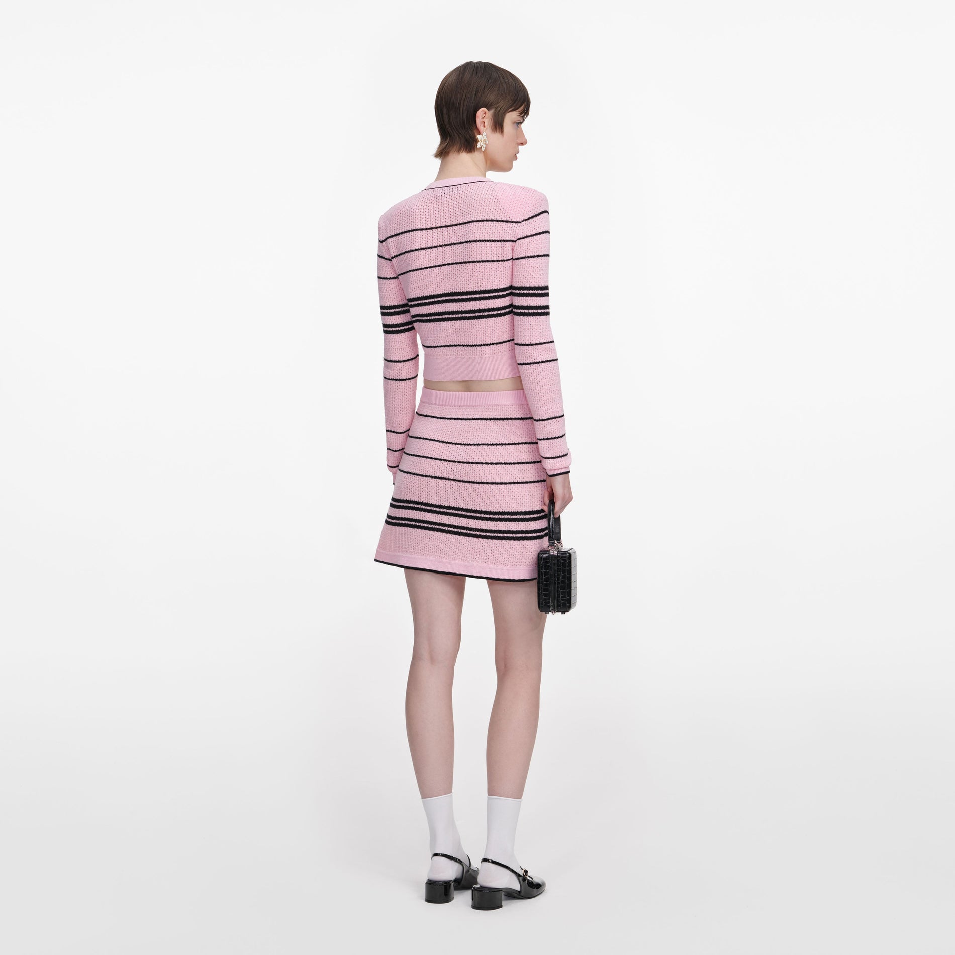 Back view of a woman wearing the Pink Stripe Knit Mini Skirt