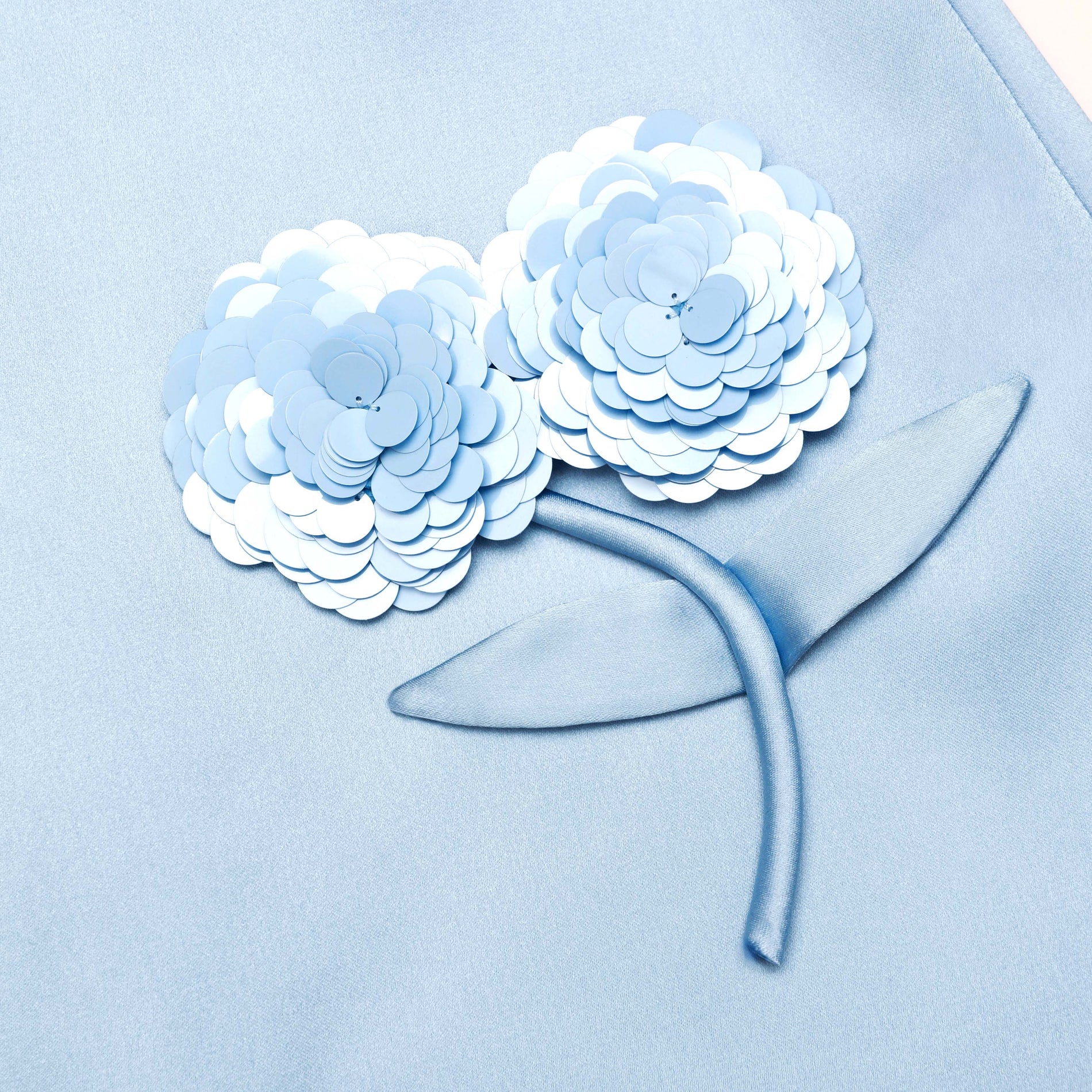 A close up of the fabric for the Blue Satin 3D Sequin Flower Mini Skirt