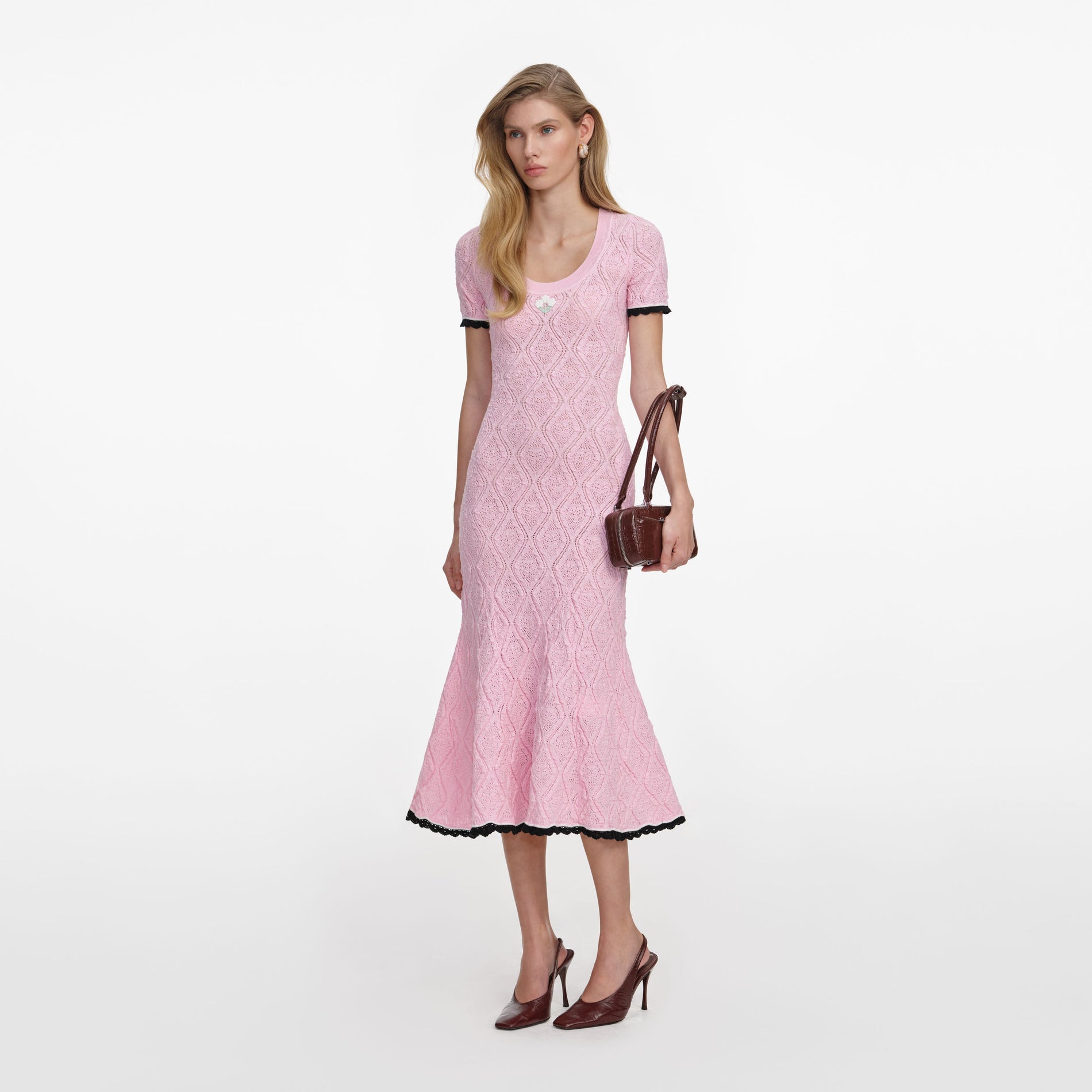 Side view of a woman wearing the Pink Pointelle Knit Midi Dress
