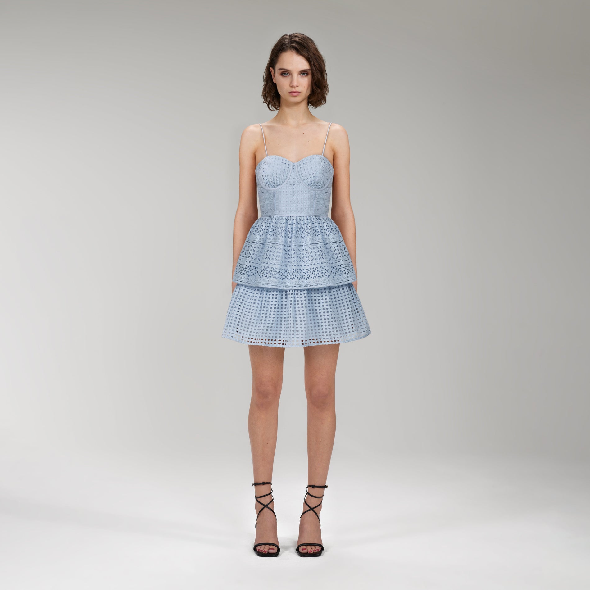 A woman wearing the Light Blue Cotton Broderie Anglaise Mini Dress