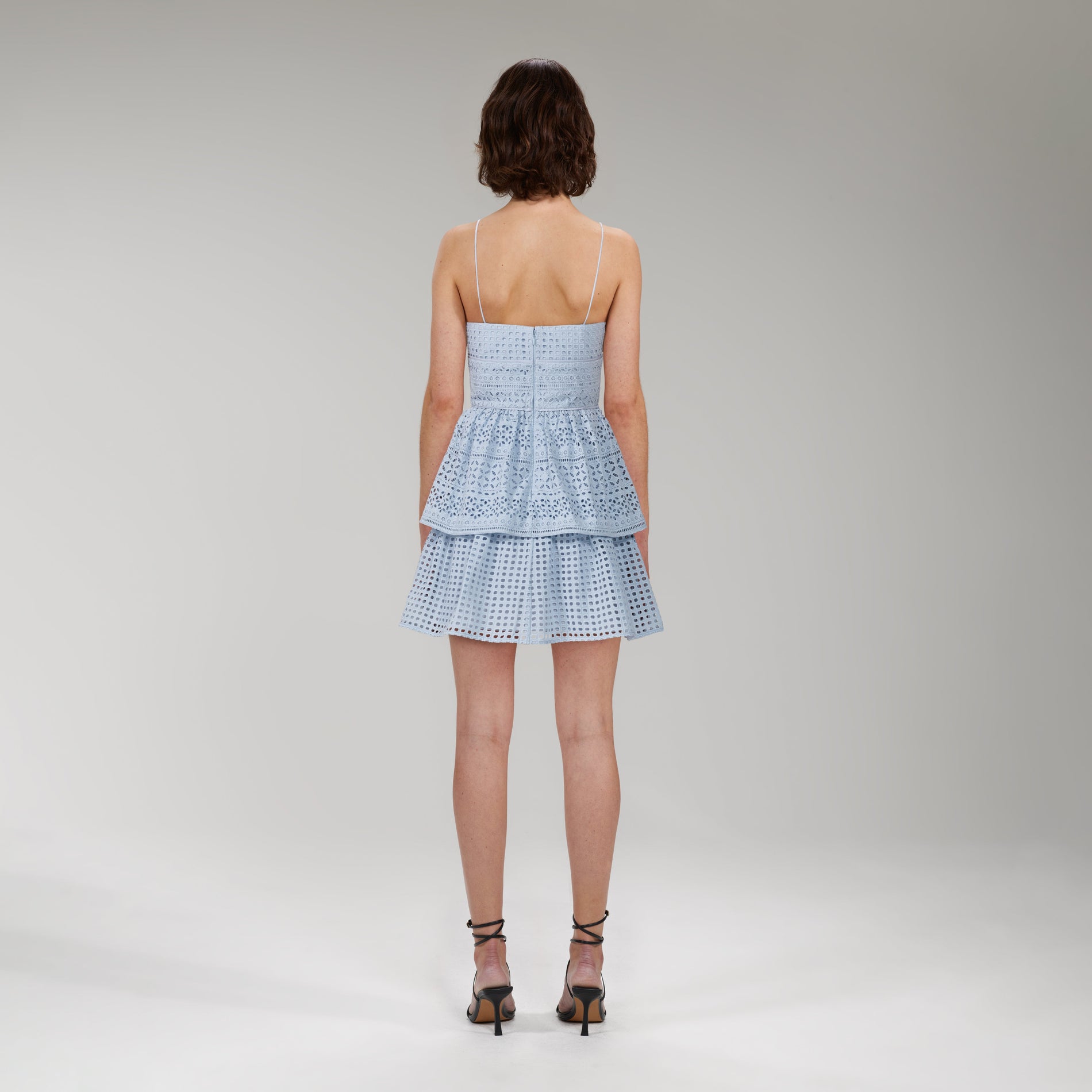 A woman wearing the Light Blue Cotton Broderie Anglaise Mini Dress